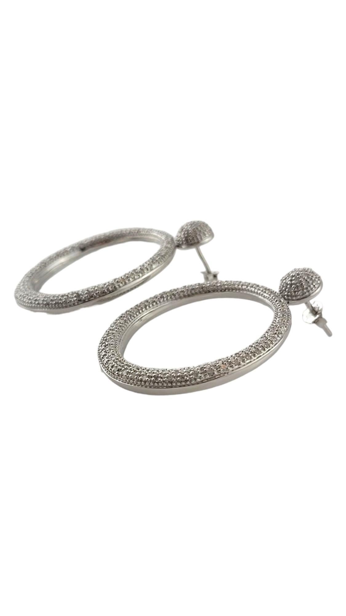 These sparkling hoop earrings each feature 102 round single cut diamonds set in classic 14K white gold.  

Push back closures.

Approximate total diamond weight:  1.0 ct.

Diamond color: I

Diamond clarity: I1-I2

Size: 38 mm x 31 mm

Weight:   8.2