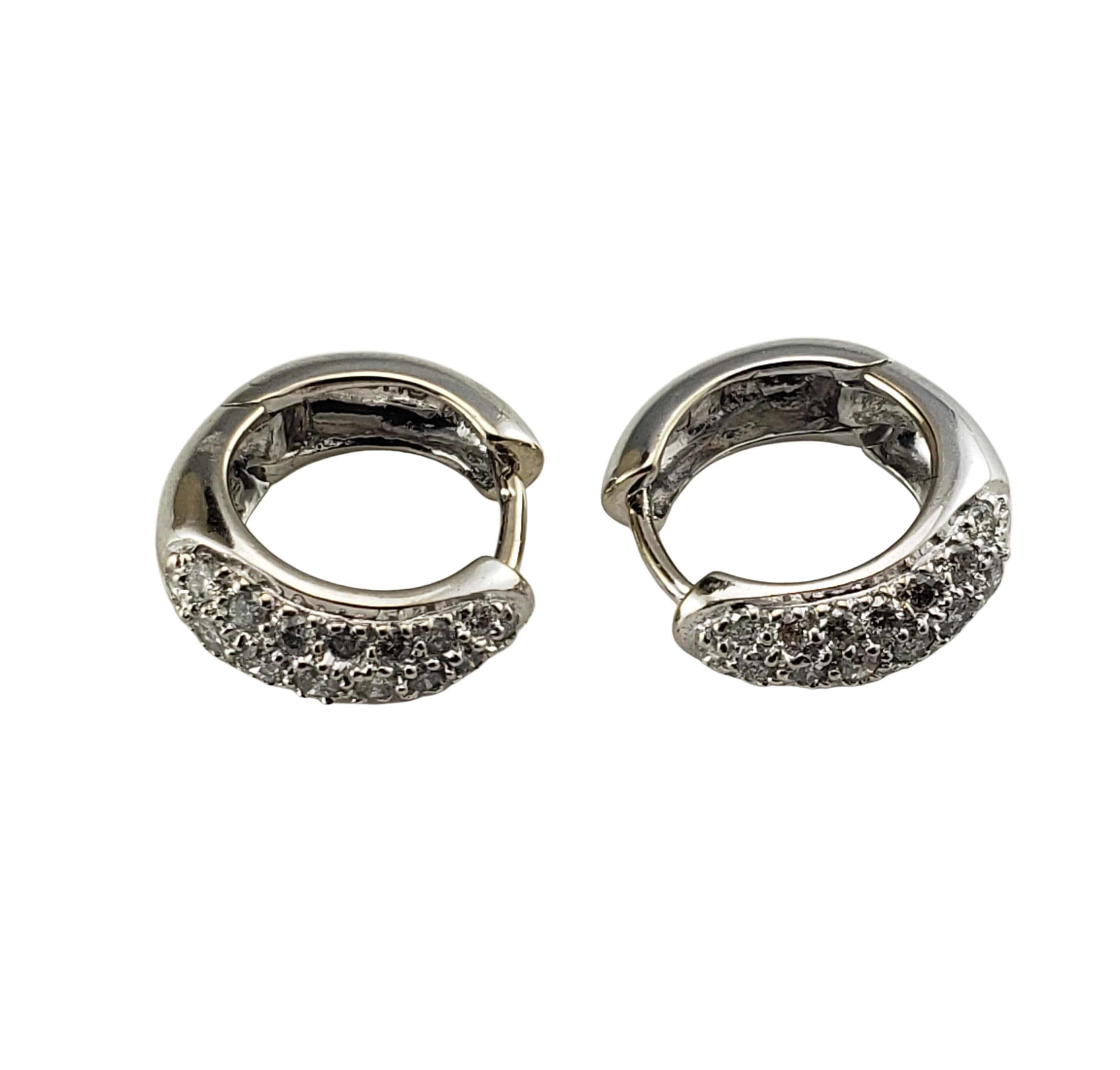 14 Karat White Gold and Diamond Hoop Earrings-

These sparkling hinged hoop earrings each feature 21 round brilliant cut diamonds set in classic 14K white gold.  Width:  4 mm

Approximate total diamond weight:  .60 ct.

Diamond color:  H-I

Diamond