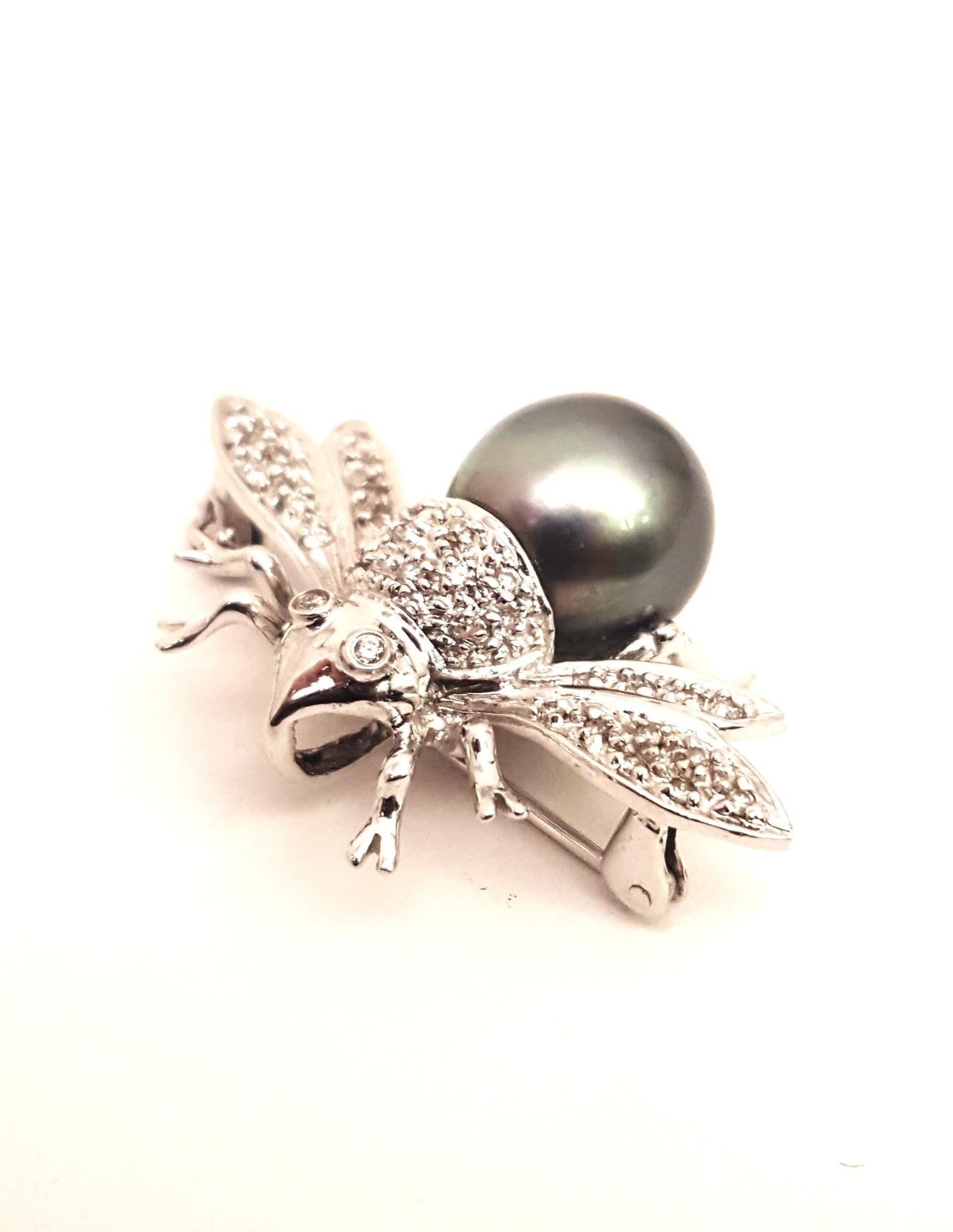This darling bee brooch would be a fabulous addition to your fine jewelry collection!  Crafted in both sterling silver and 14 karat white gold, the body sports a faux black pearl measuring 11 mm wide.  Top of body and wings boast white diamonds. 
