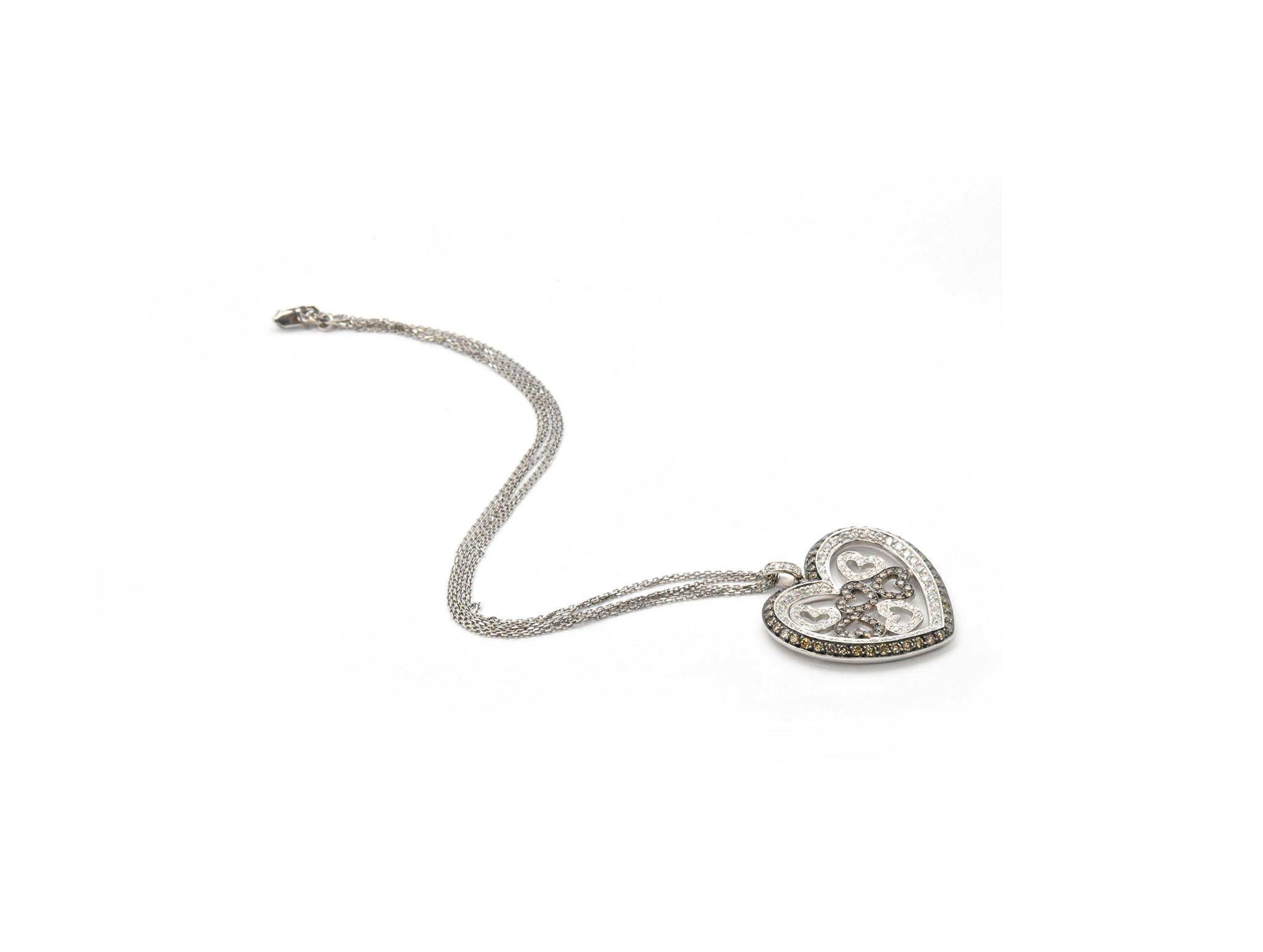 This fabulous necklace is made in solid 14k white gold. The heart pendant is set with both white and champagne diamonds for a total weight of 2.92 carats. The pendant measures 36x36mm, and it slides along a triple layer 14k white gold chain