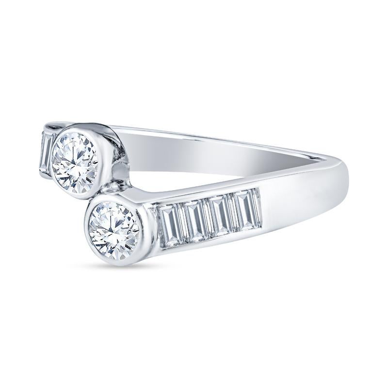 This 14 karat white gold bypass ring features 0.40 carat total weight in round brilliant bezel set diamonds accented by 0.45 carat total weight in channel set baguette diamonds. This ring is a size 5 but can be resized upon request.