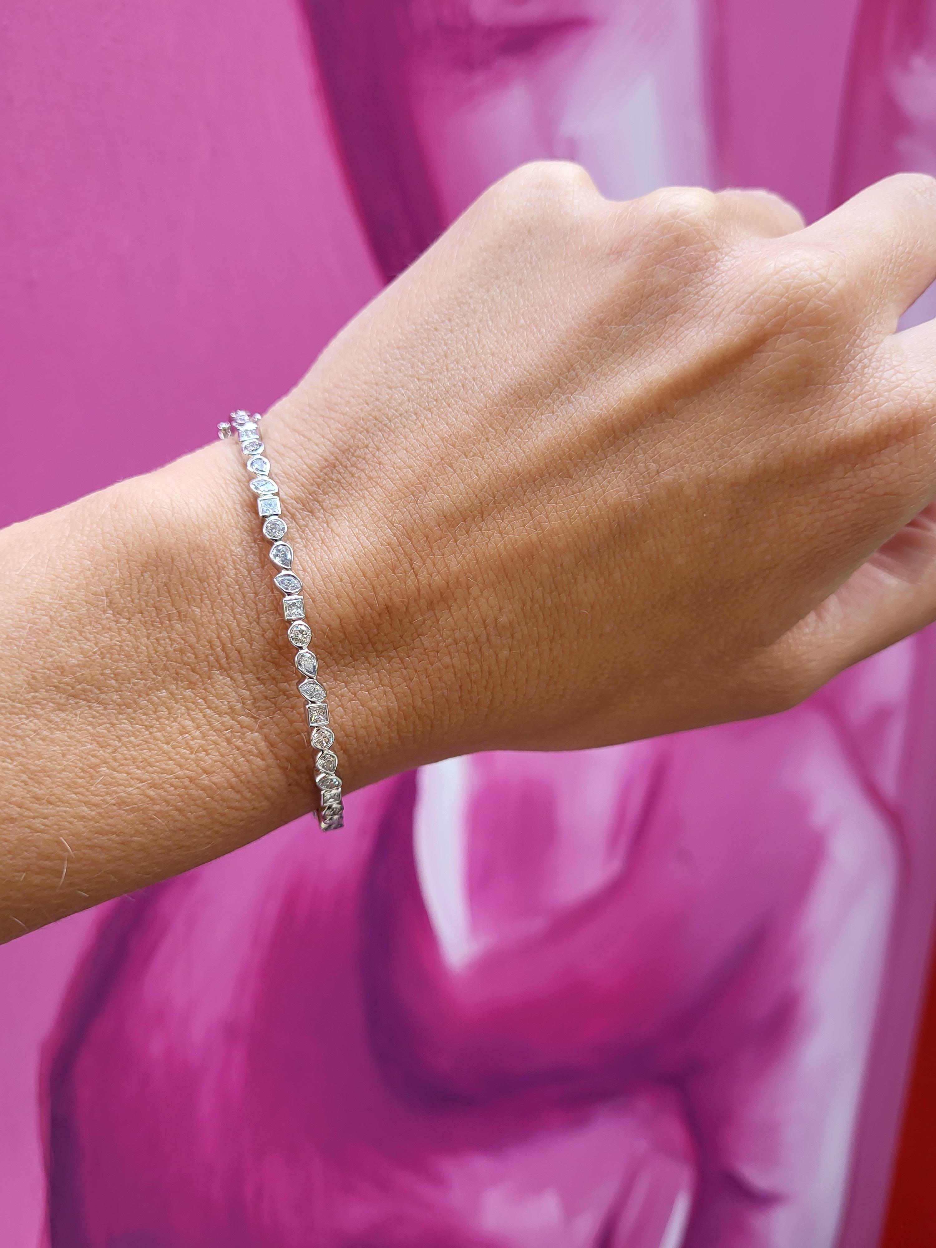 Este brazalete engastado en bisel tiene 0,40 quilates de diamantes redondos, 0,30 quilates de diamantes marquesa, 0,25 quilates de diamantes talla princesa y 0,35 quilates de diamantes en forma de pera engastados en oro blanco de 14 quilates.
