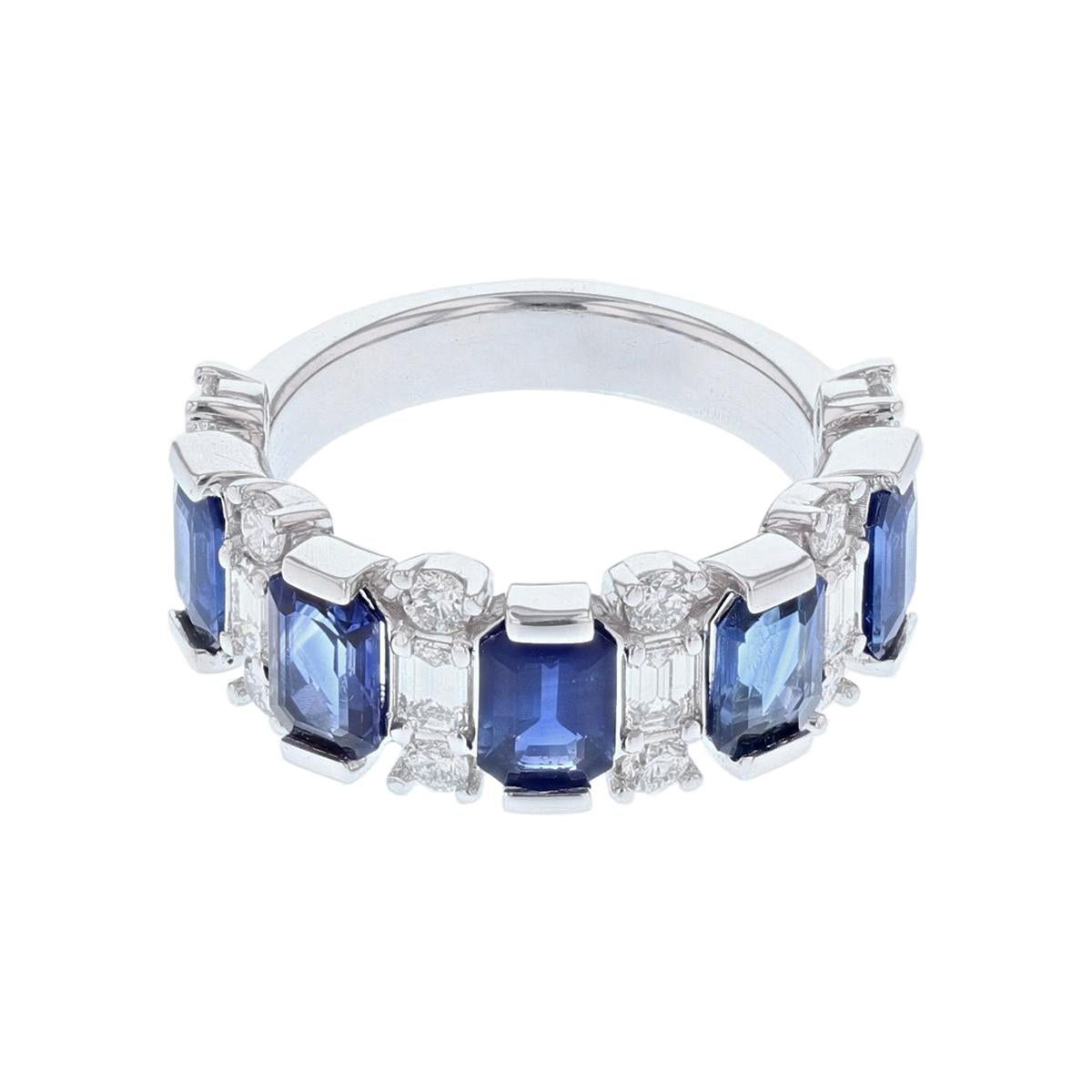 This ring is made in 14 karat white gold featuring five Emerald cut, channel set Blue Sapphires weighing 2.94 carats and six Emerald cut, channel set Diamonds weighing 0.59 carats with a color grade (H/I) and a clarity grade (VS). 