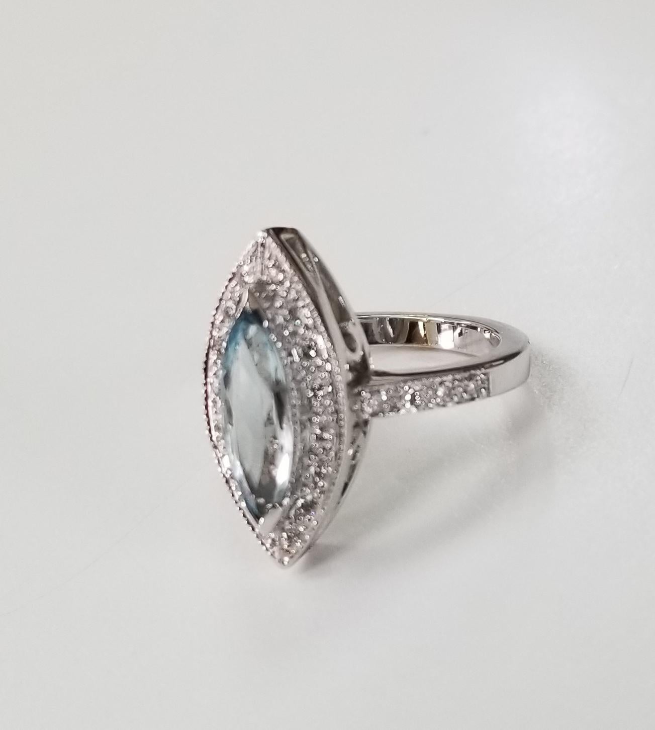 14k white gold Blue Topaz and diamond ring, containing 1 marquise blue topaz weighing 1.00cts. and 18 round diamonds weighing .35pts.  This ring is a size 6.5 but we will size to fit for free.