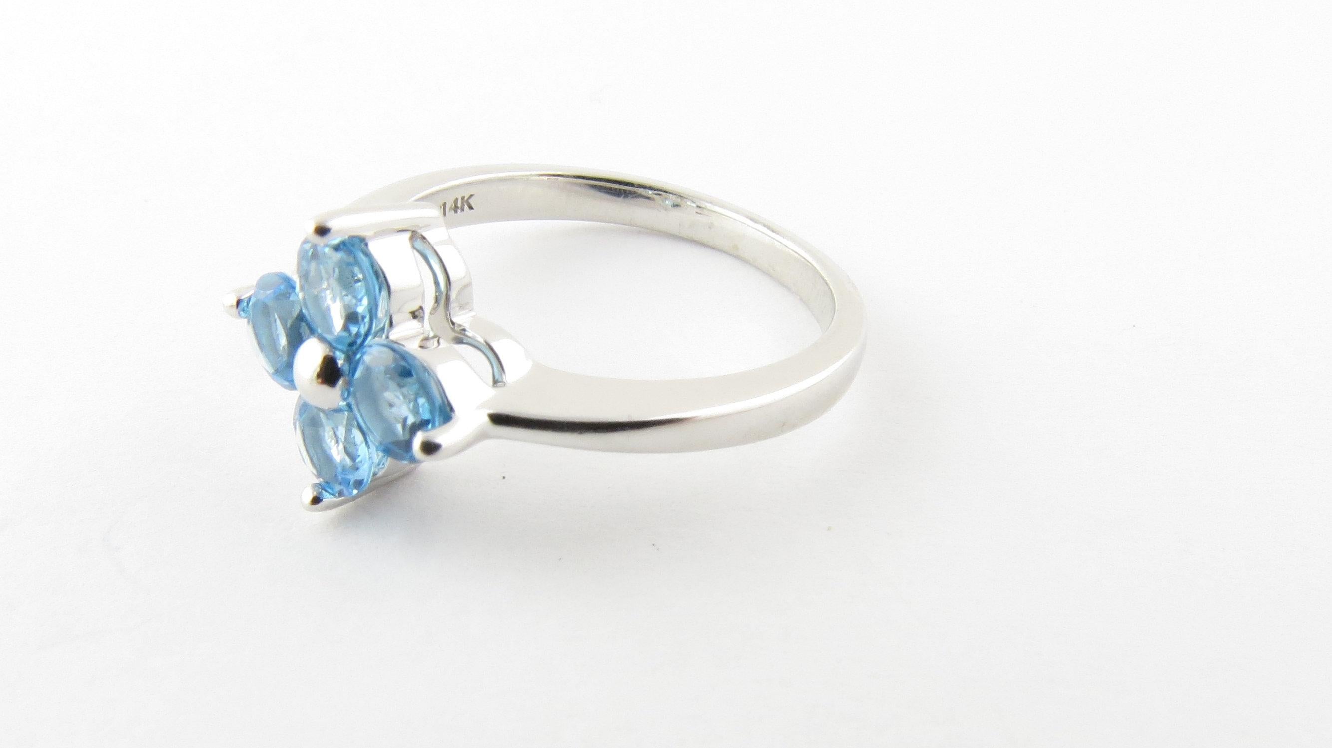 Vintage 14 Karat White Gold Blue Topaz Ring Size 6.75- This lovely ring features four round blue topaz gemstones (4 mm each) set in classic 14K white gold. Top of ring measures 11 mm x 11 mm. Shank measures 2 mm. Ring Size: 6.75 Weight: 2.2 dwt. /