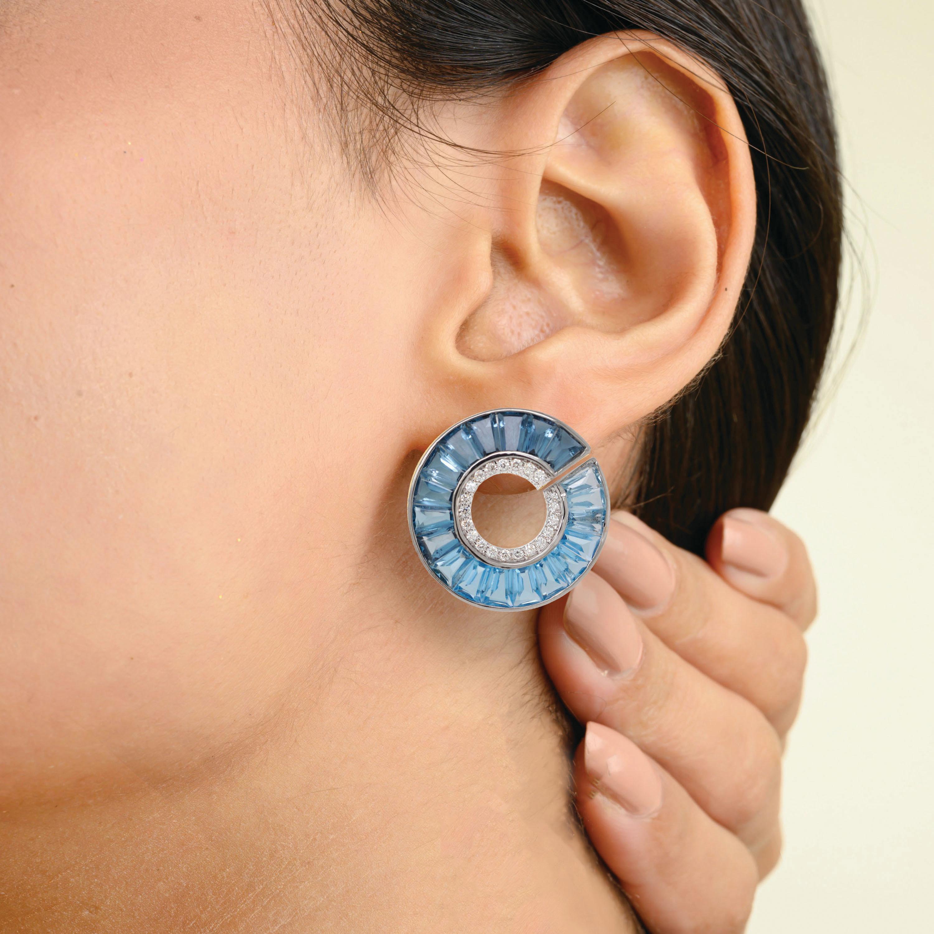 These stunning 14K White Gold Circular Stud Earrings are a luminous celebration of color, precision, and artistry. Each earring features a flawless channel of tapered baguette-cut blue topaz gemstones, expertly arranged to create a captivating ombré