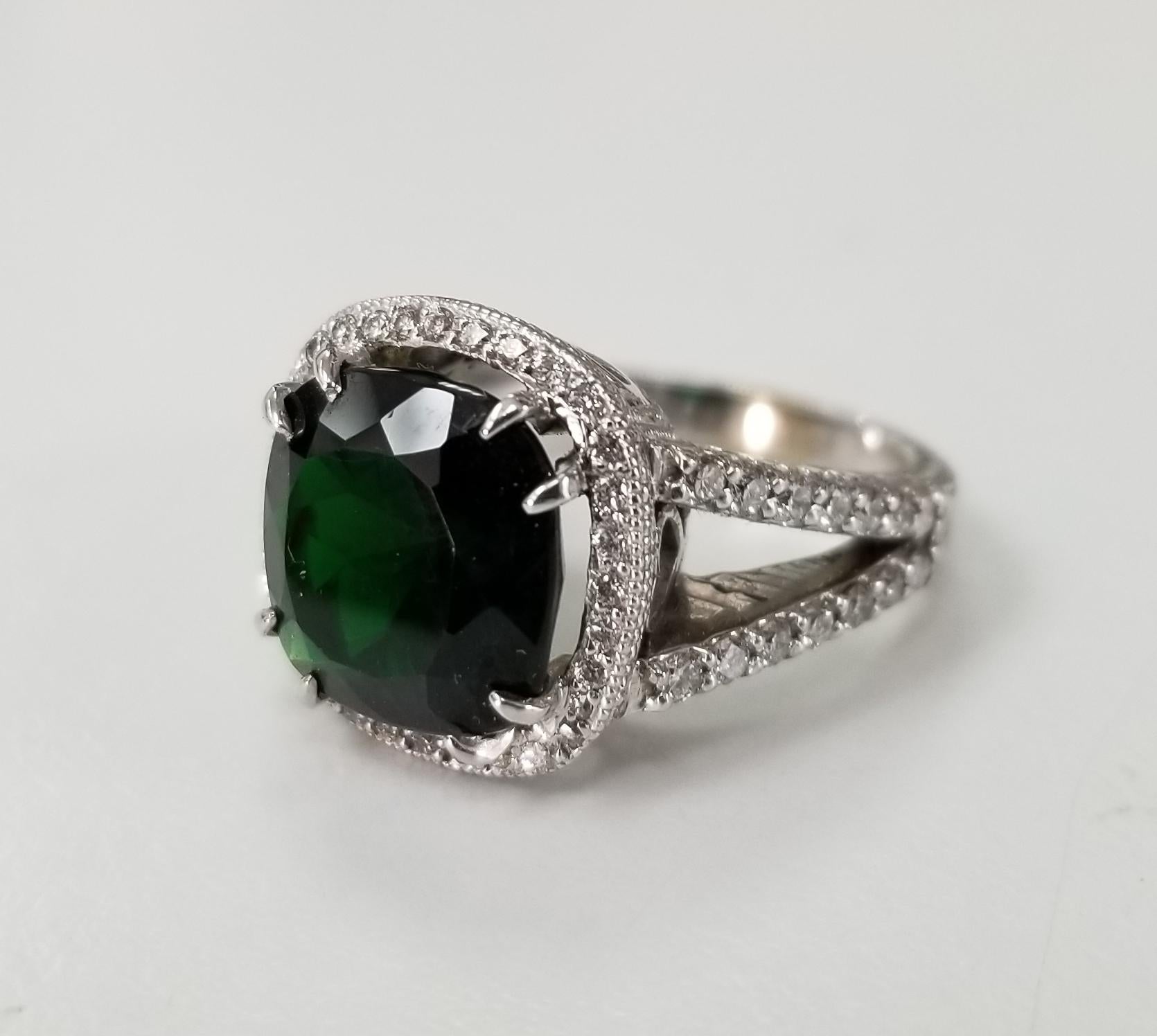 14k white gold Chrome diopside and diamond ring, containing 1 cushion cut Chrome diopside weighing 4.70cts. and 32 round diamonds of very fine quality weighing .60pts. On a hand engraved setting.  This ring is a size 5.5 but we will size to fit for