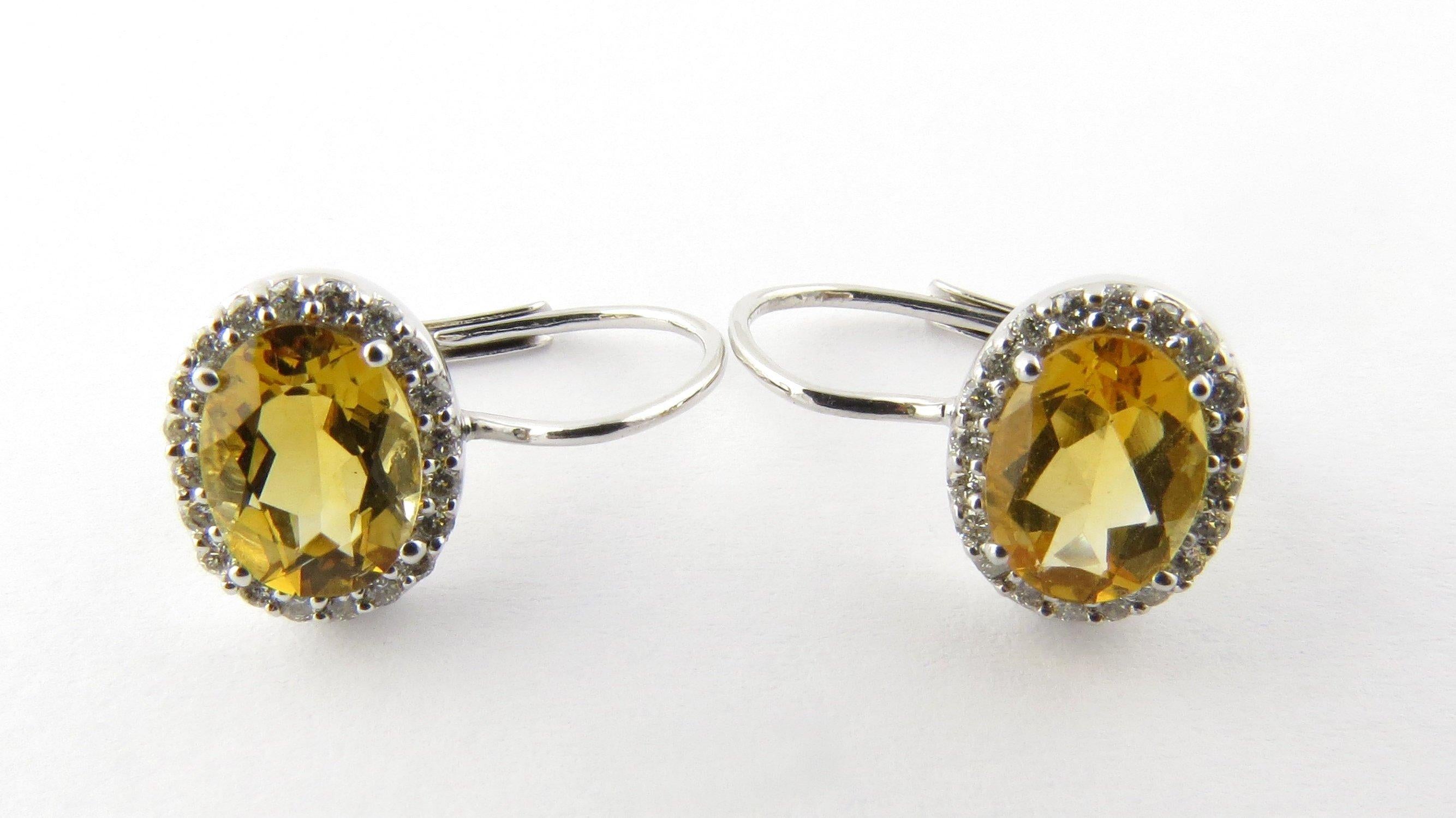 Vintage 14 Karat White Gold Citrine and Diamond Earrings- 
These stunning earrings each feature one oval citrine stone (8 mm x 6 mm) surrounded by 20 round brilliant cut diamonds set in classic 14K white gold. Hinge back closures. 
Matching ring: