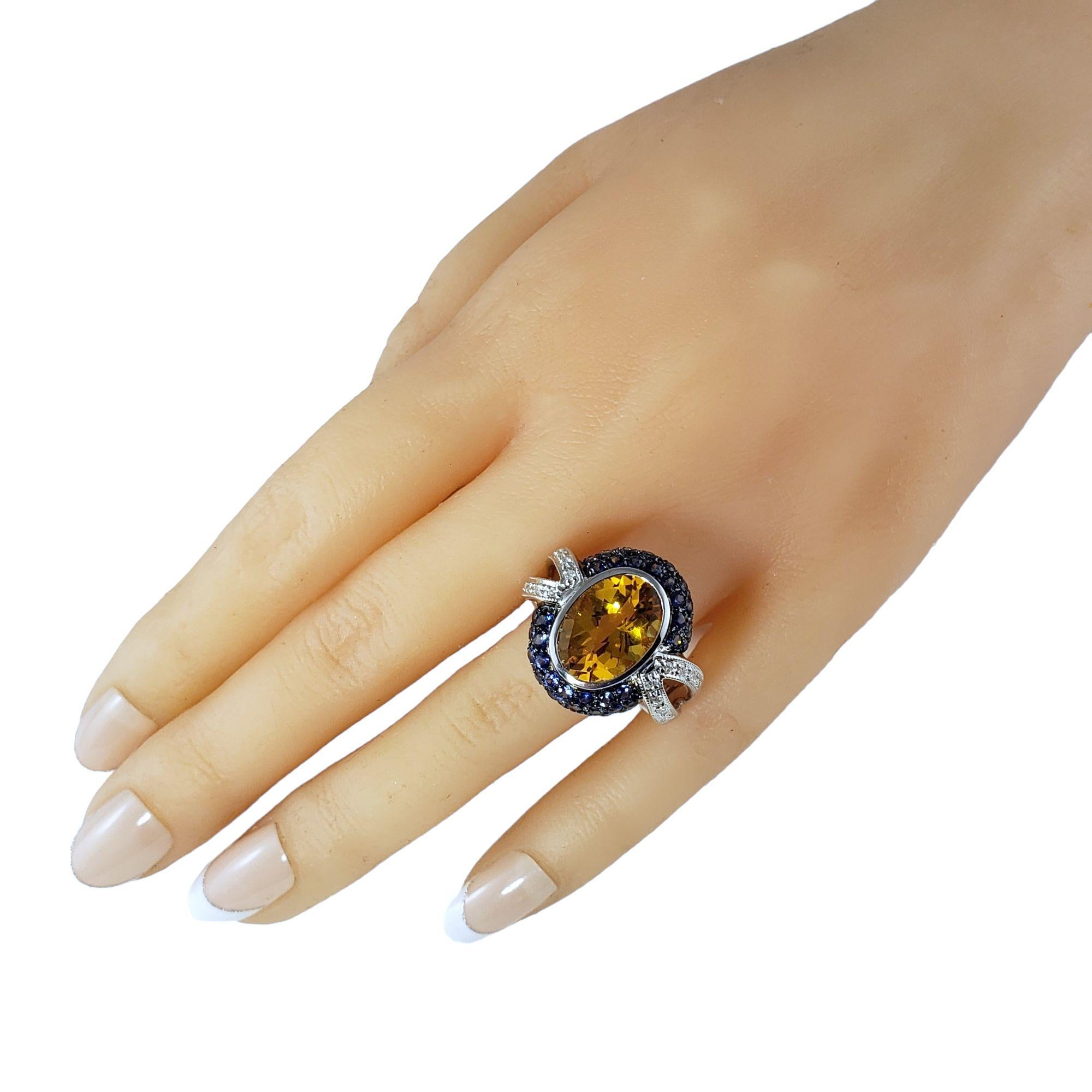 Vintage 14 Karat White Gold Citrine, Diamond and Sapphire Ring Size 10.25 JAGi Certified-

This stunning ring features one oval citrine (13.8 mm x 10 mm), 50 round blue sapphires and 12 round brilliant cut diamonds set in beautifully detailed 14K