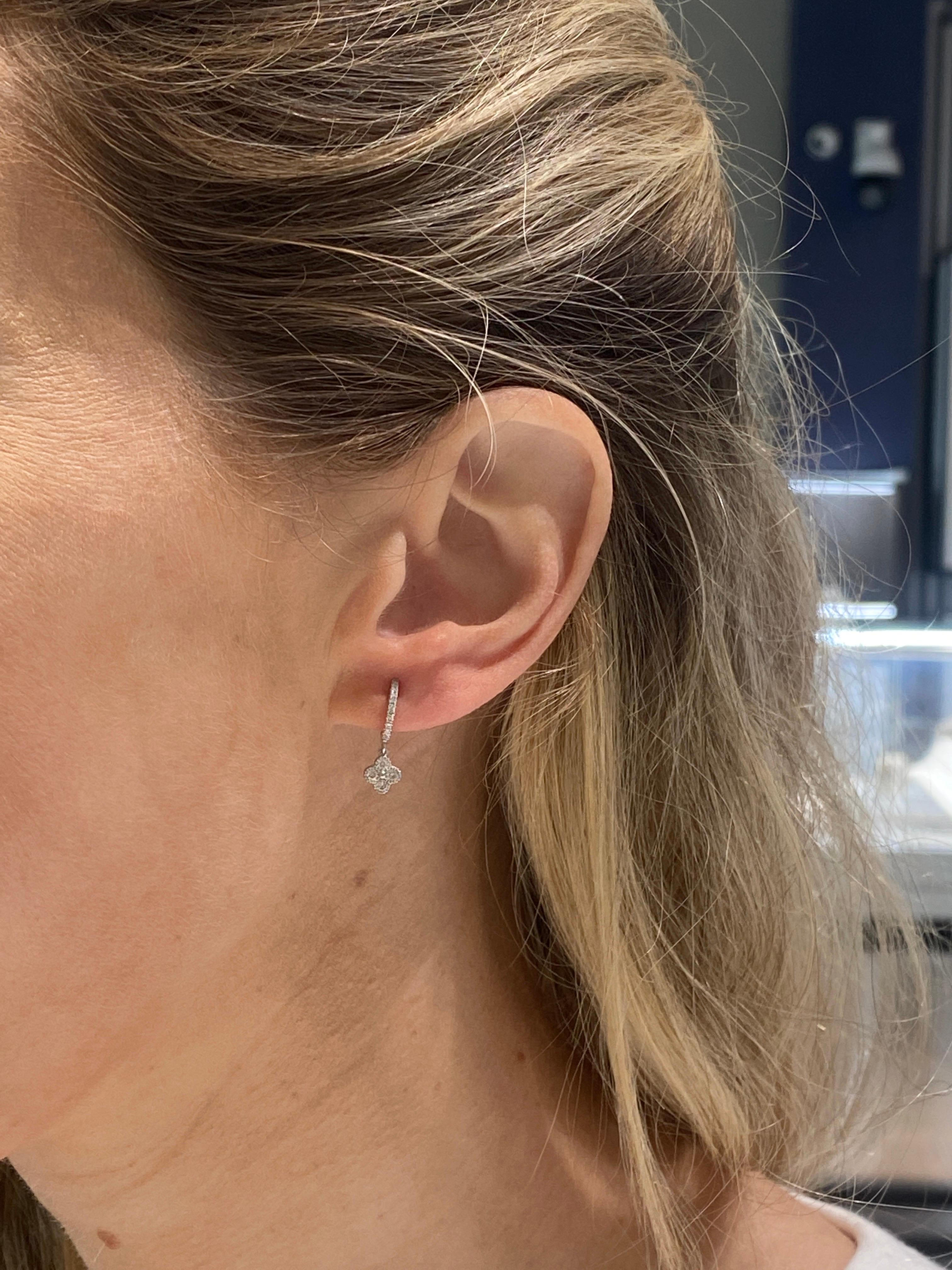 These 14 karat white gold earrings feature a clover that dangles from the hoop with round brilliant diamonds. 
Measurements: Huggie height 10mm/Clover 6mm