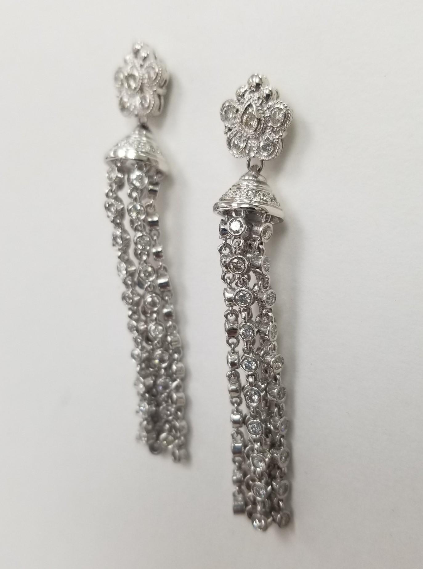 14k white gold diamond dangle earrings, containing 132 round full cut diamonds weighing 3.75cts. and  2 inches of bezel set diamonds dangling from a diamond 