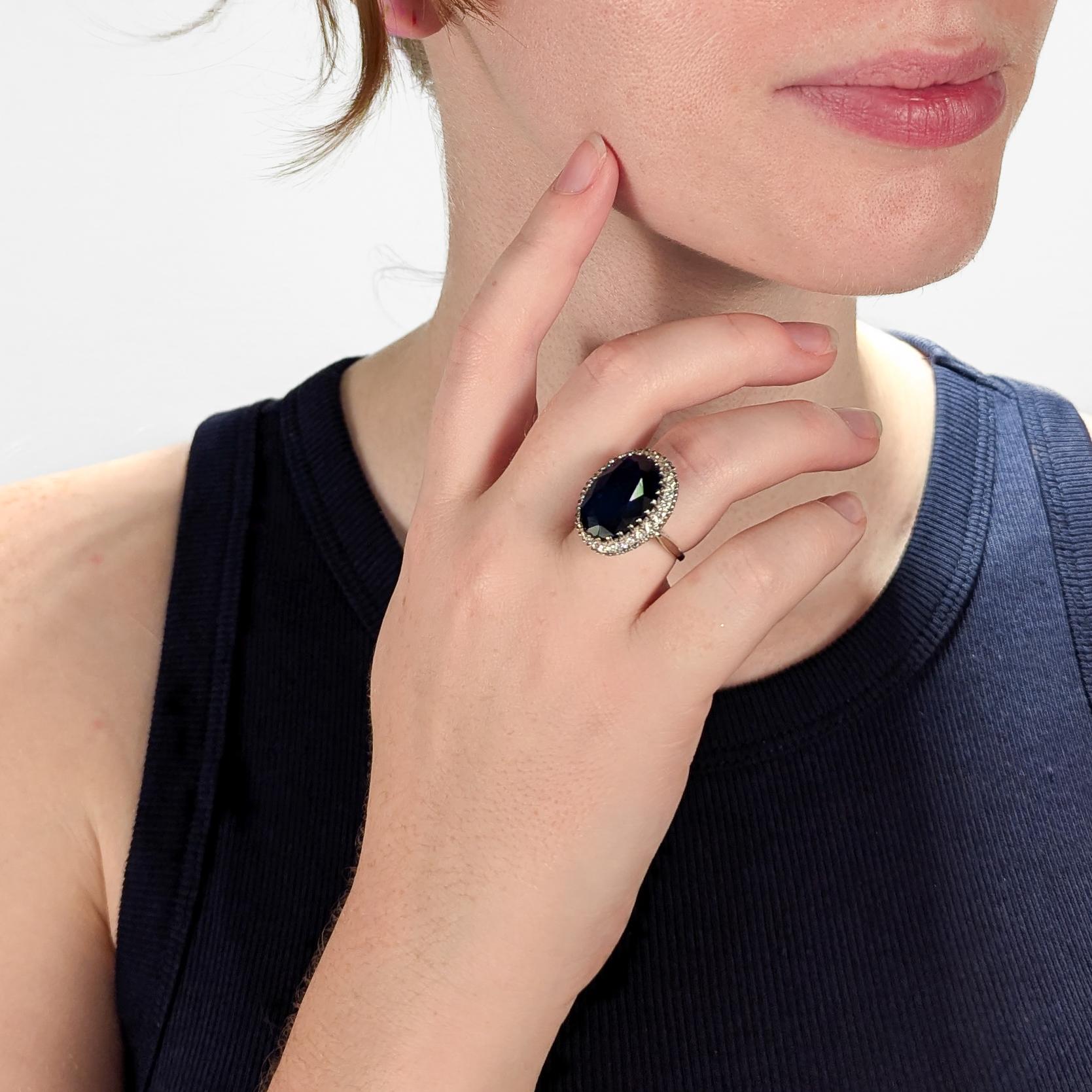 A very fine gold and multi-gemstone cocktail ring.

In 14k white gold. 

Set with a large deep blue oval-cut topaz surrounded by a halo of 24 small round-cut diamonds.

Simply an eye-catching ring that is fun to wear and makes you look!

Date:
20th