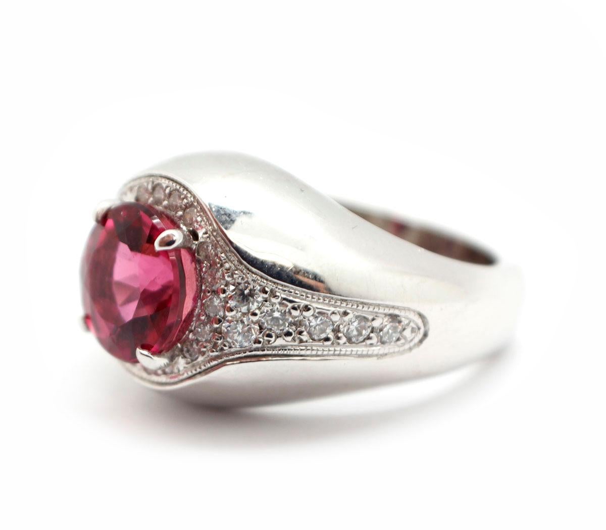 This 14k white gold ring has a beautiful round pink tourmaline at its center. The stone is 3.11 carats, and it measures 9mm in diameter. There are a total of 0.65 carats mounted into the ring around the tourmaline. These stones are G-H in color and