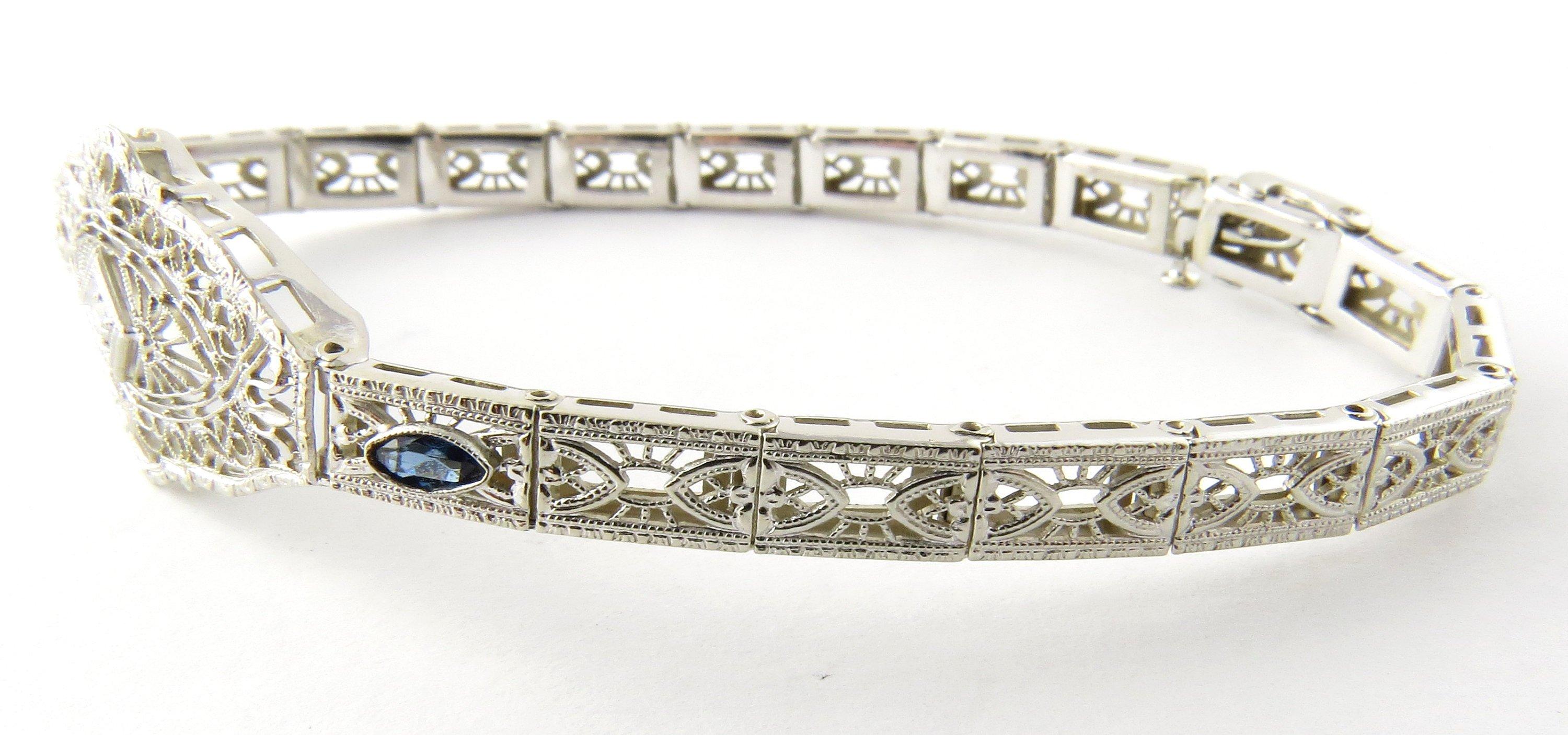 Vintage 14 Karat White Gold Diamond and Sapphire Bracelet- 
This exquisite bracelet features one single cut diamond and two marquis cut sapphires set in delicate white gold filigree. Width at widest point: 16 mm. Bracelet width: 5 mm. 
Approximate