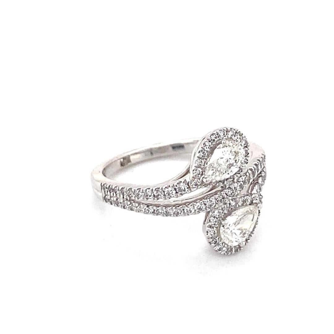 This stunning ring is made of 14 karat white gold with 1 carat total weight of diamonds. There are two pear shaped diamonds in a bypass style surrounded by a diamond halo. The ring fits a finger size 7. Don't miss out on this gorgeous statement