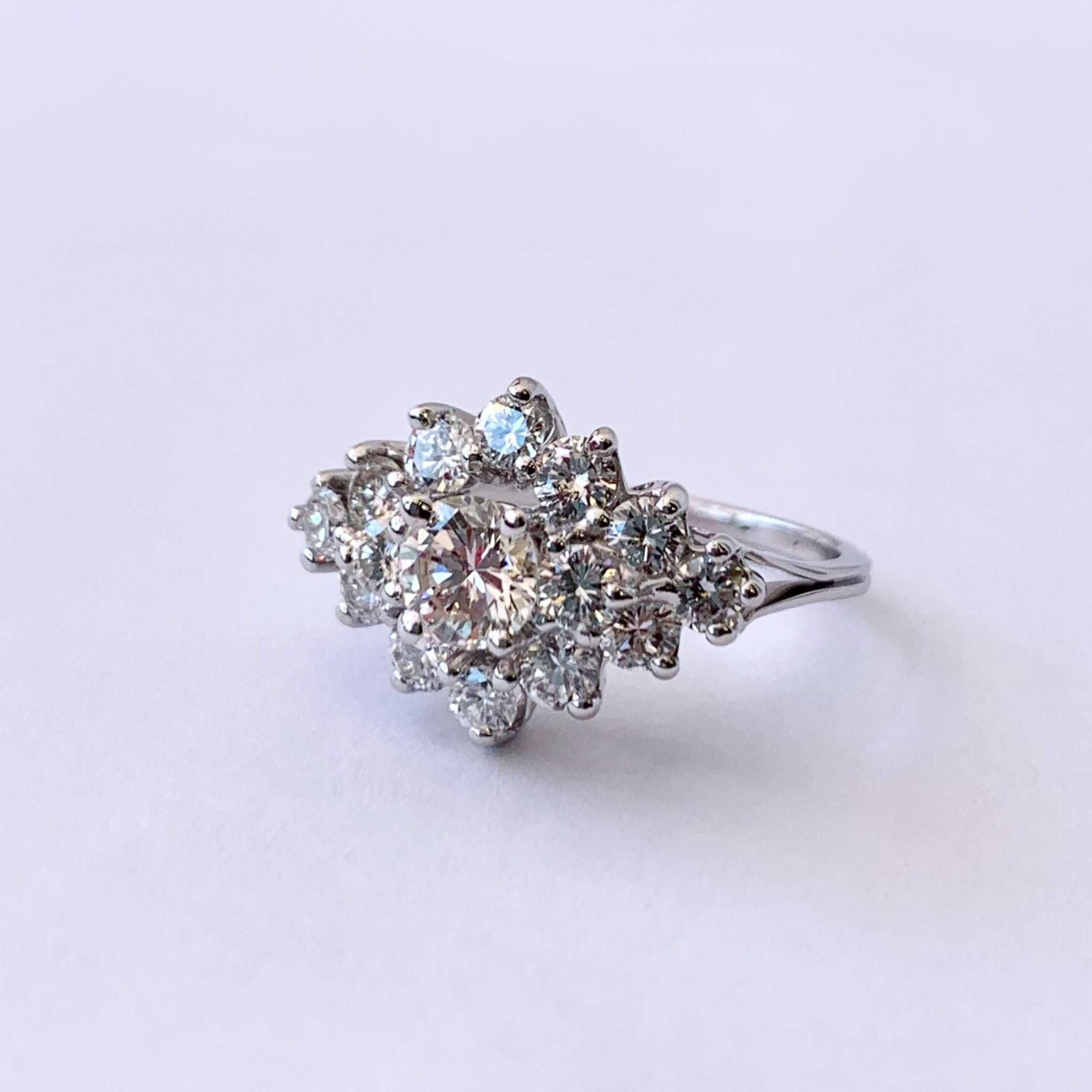 Vintage 14kt white gold cluster cocktail ring, circa 1970's. The ring is set with 15 round brilliant diamonds of varying size with a total weight of approximately 1.94cts. The diamonds average SI, in clarity, and H-I color.
*Ring sizing included
