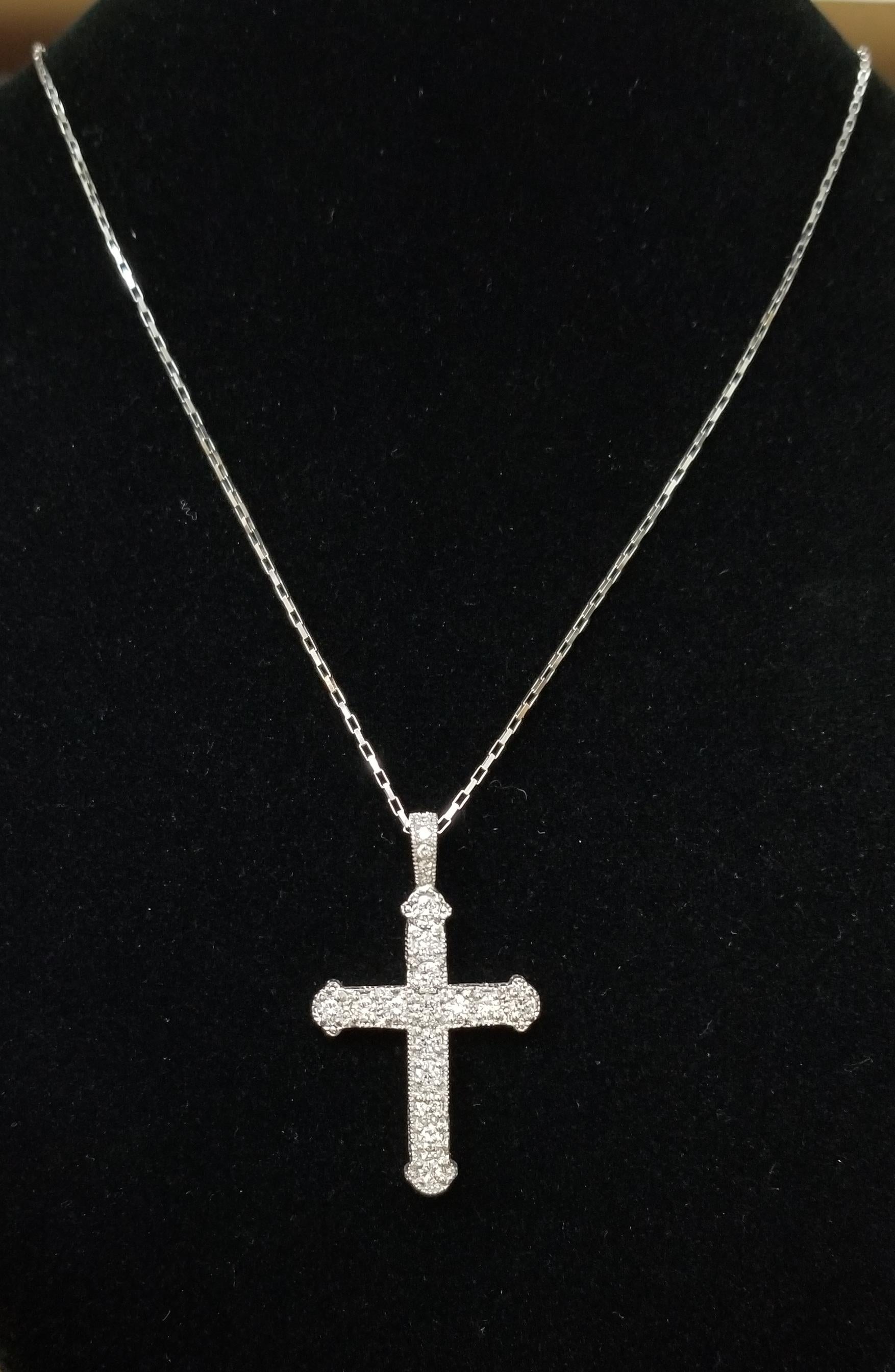 14k white gold diamond cross, containing 20 round diamonds of fine quality weighing 1.50ct. on a 20 inch elongated box chain.