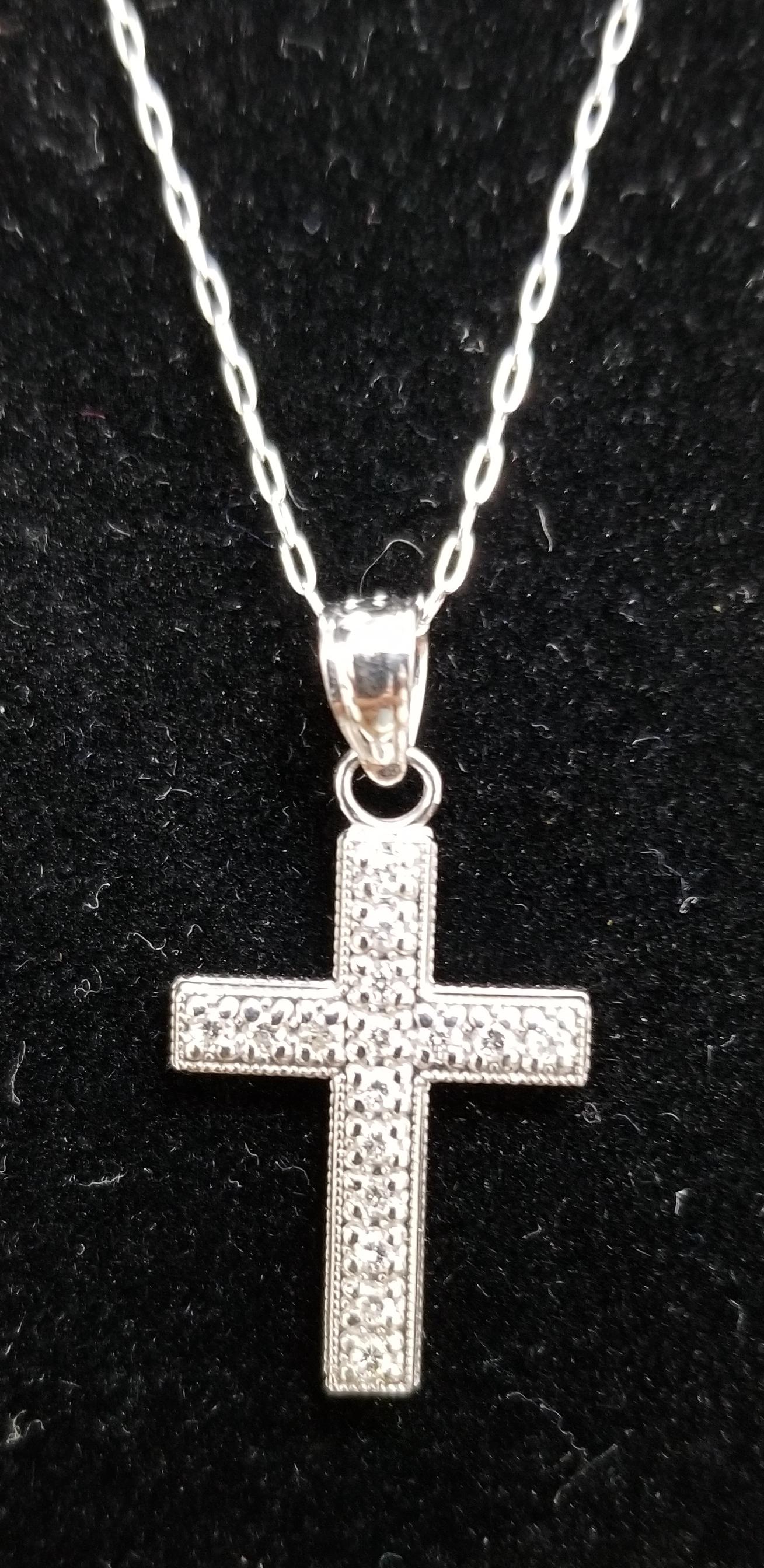 14k white gold diamond cross with 16 round full cut diamonds weighing .15pts. of nice quality on a 16 inch link chain.