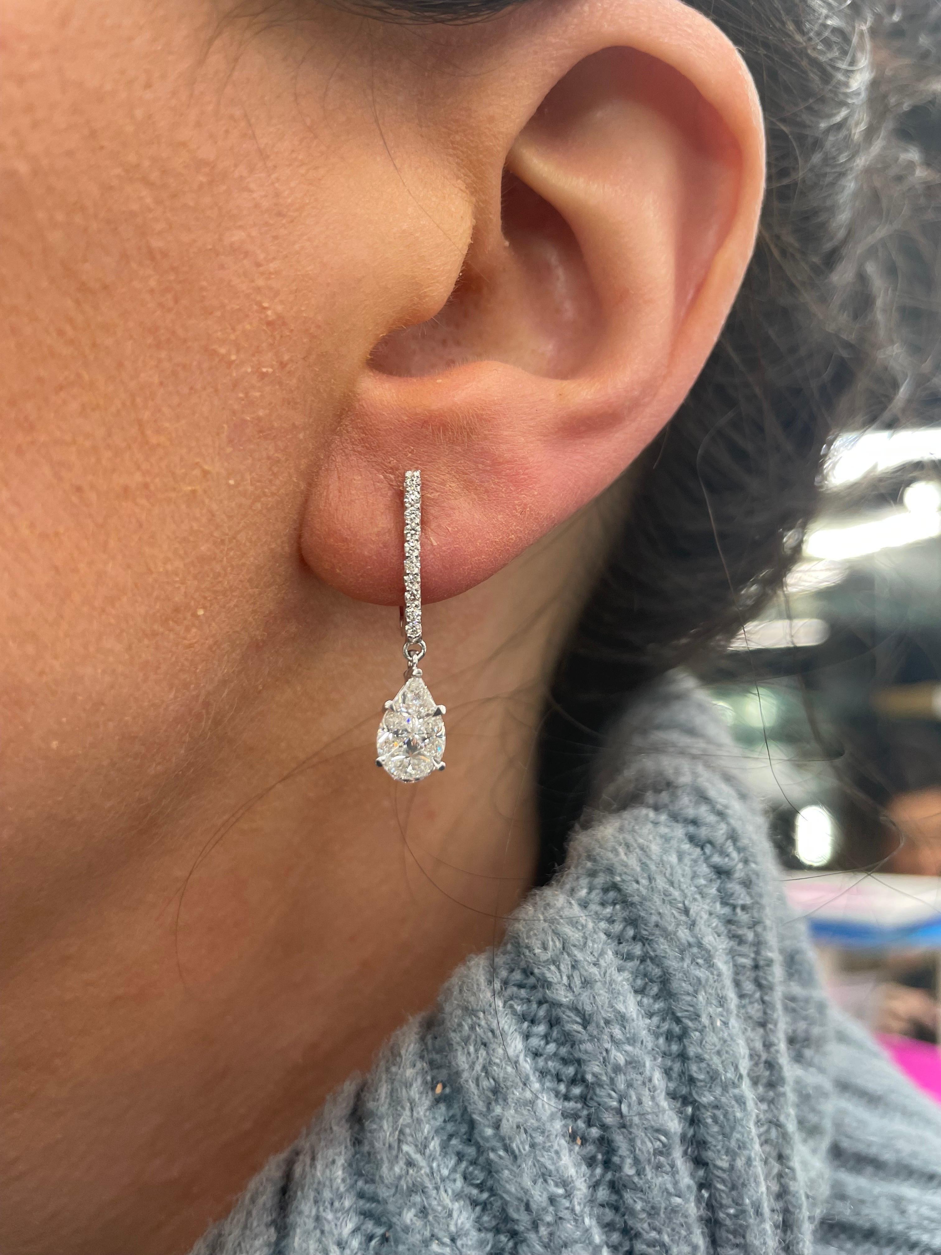14 Karat White gold drop earrings featuring 20 round brilliants weighing 0.19 carats and 8 special cut diamonds to create a pear shape illusion weighing 1.21 carats. 
Color H
Clarity VS1-VS2