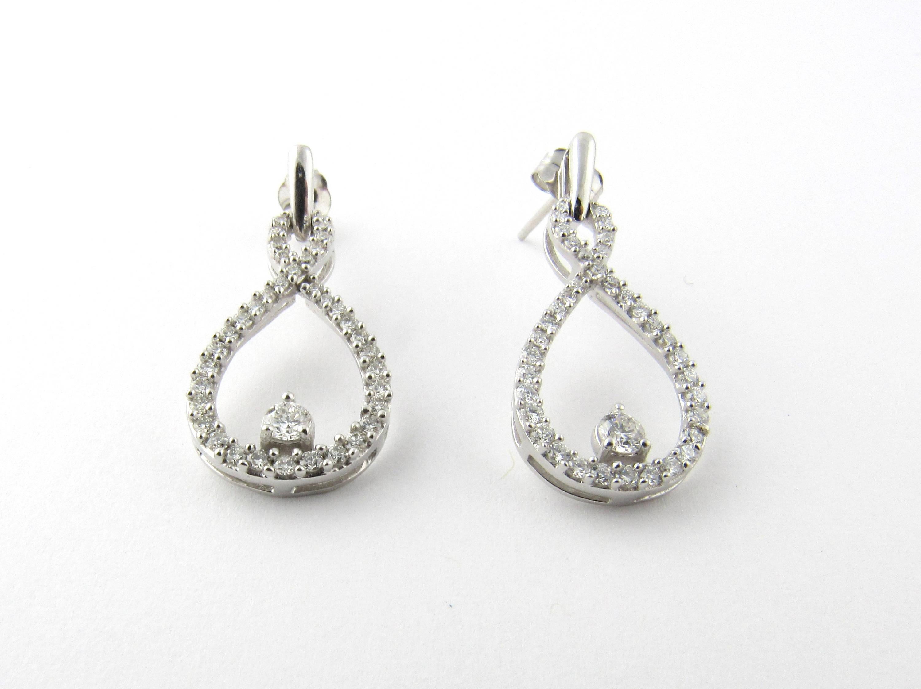 Vintage 14 Karat White Gold Diamond Earrings-

These tear drop earrings feature a center diamond in each which is approx. .05 cts for a total of .10cts.

37 round brilliant diamonds surround the center of each of these earrings for a total of 74
