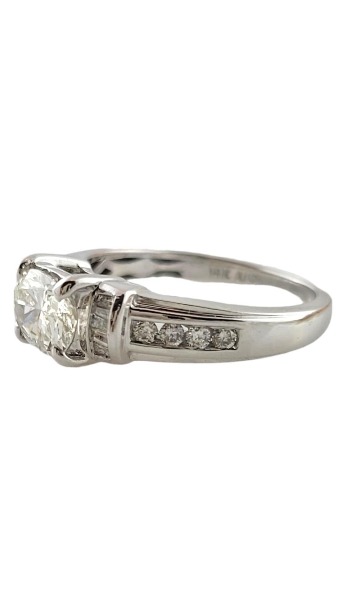 This sparkling engagement ring features one oval shaped diamond (1.0 ct.) accented with eight round brilliant cut diamonds and 10 baguette cut diamonds set in classic 14K white gold.  

Width:  6 mm.  Shank:  1.5 mm.

Total diamond weight:  1.25