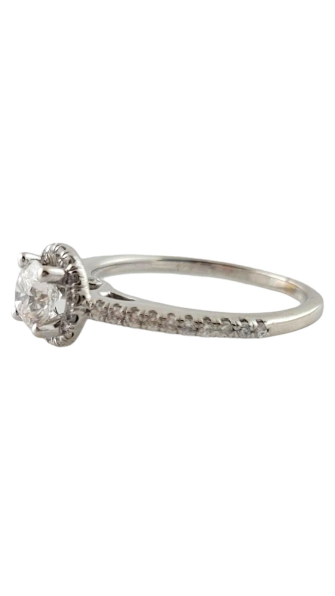 This sparkling 14K white gold ring features one round brilliant cut diamond in its center accented with 38 round brilliant cut diamonds set in the halo and band.

  Width:  7 mm.  Shank:  1 mm.

Center diamond weight:  .52 ct.

Accent diamond total