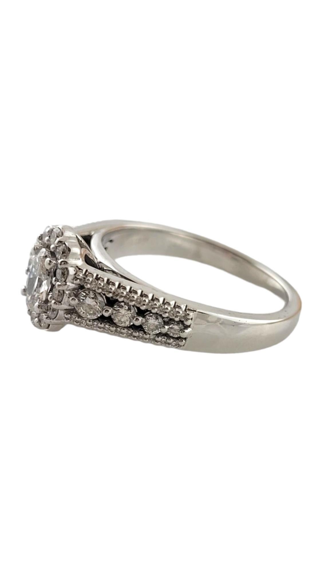 This sparkling engagement ring features one oval cut diamond (.38 ct.) surrounded by 60 round brilliant cut diamonds and set in beautifully detailed 14K white gold.  Shank:  3 mm.

Total diamond weight:  1.0 ct.

Diamond color:  I

Diamond clarity: 