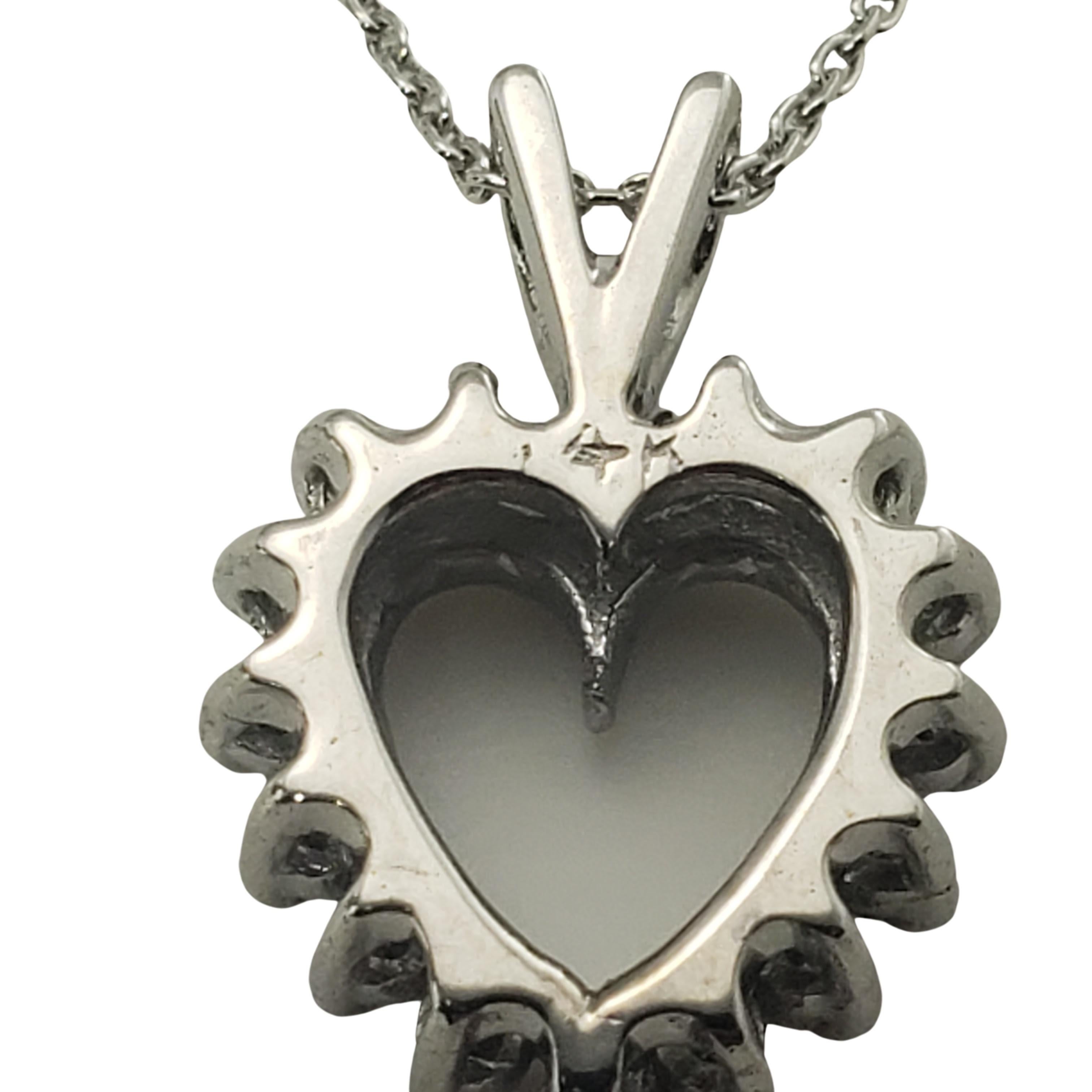 Vintage 14 Karat White Gold Diamond Heart Pendant Necklace-

This sparkling heart pendant features 16 round brilliant cut diamonds set in classic 14K white gold. Suspends from a classic cable necklace.

Approximate total diamond weight: .16