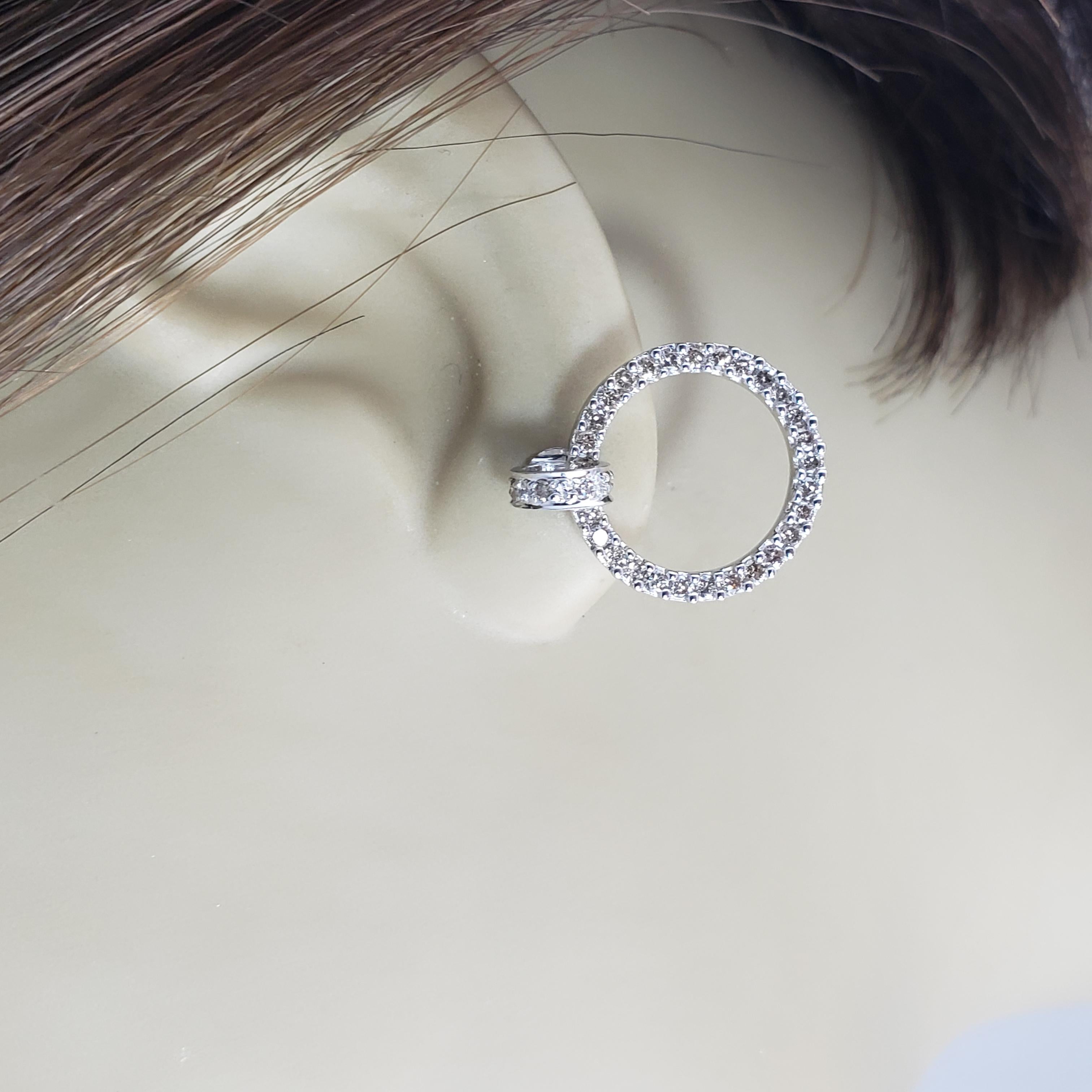 Vintage 14 Karat White Gold and Diamond Hoop Earrings-

These sparkling hoop earrings each feature 35 round brilliant cut diamonds set in classic 14K white gold. Push back closures.

Approximate total diamond weight: .70 ct.

Diamond color: