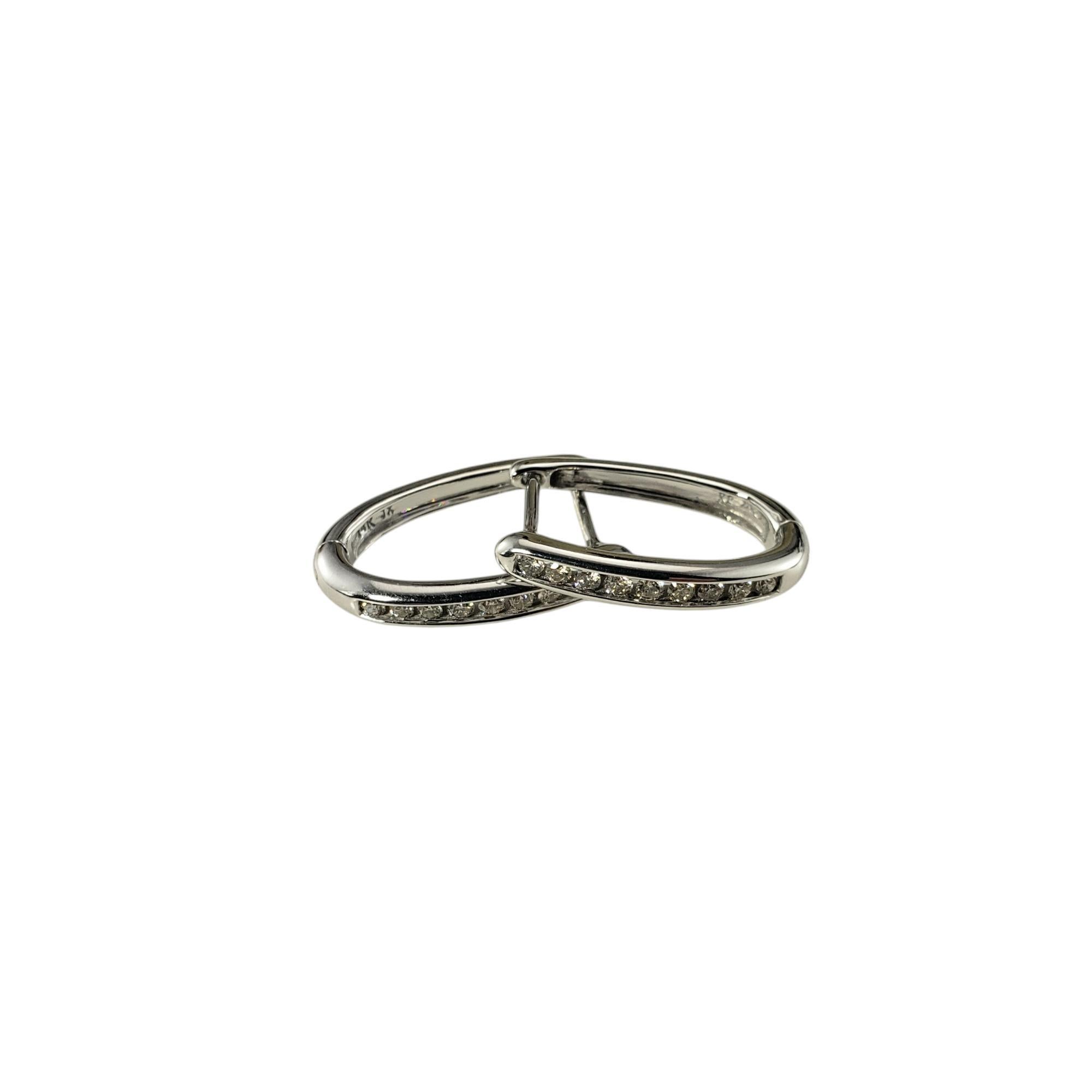 14 Karat White Gold and Diamond Oval Hoop Earrings-

These sparkling oval hoop earrings each feature nine round brilliant cut diamonds set in classic 14K white gold. Hinged closures.

Approximate total diamond weight: .18 ct.

Diamond color: