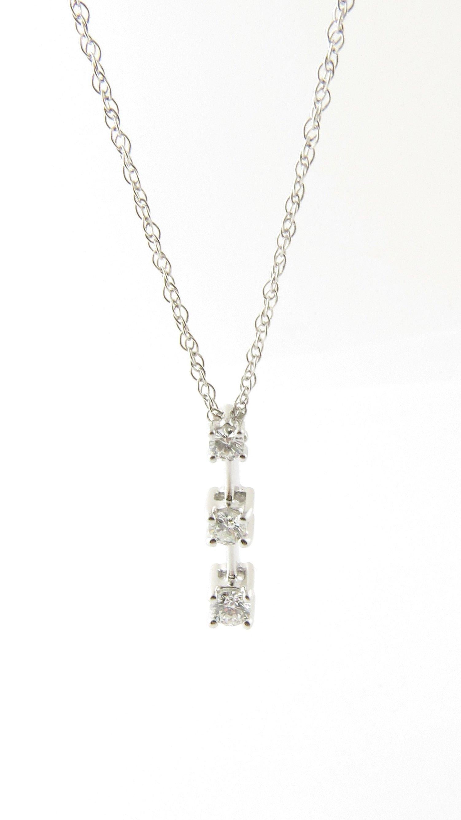 Vintage 14 Karat White Gold Diamond Pendant Necklace. This sparkling pendant features three round brilliant cut diamonds (.05 ct., .07 ct., .10 ct.) suspended from a classic 14K white gold necklace. 
Approximate total diamond weight: .22 ct. Diamond