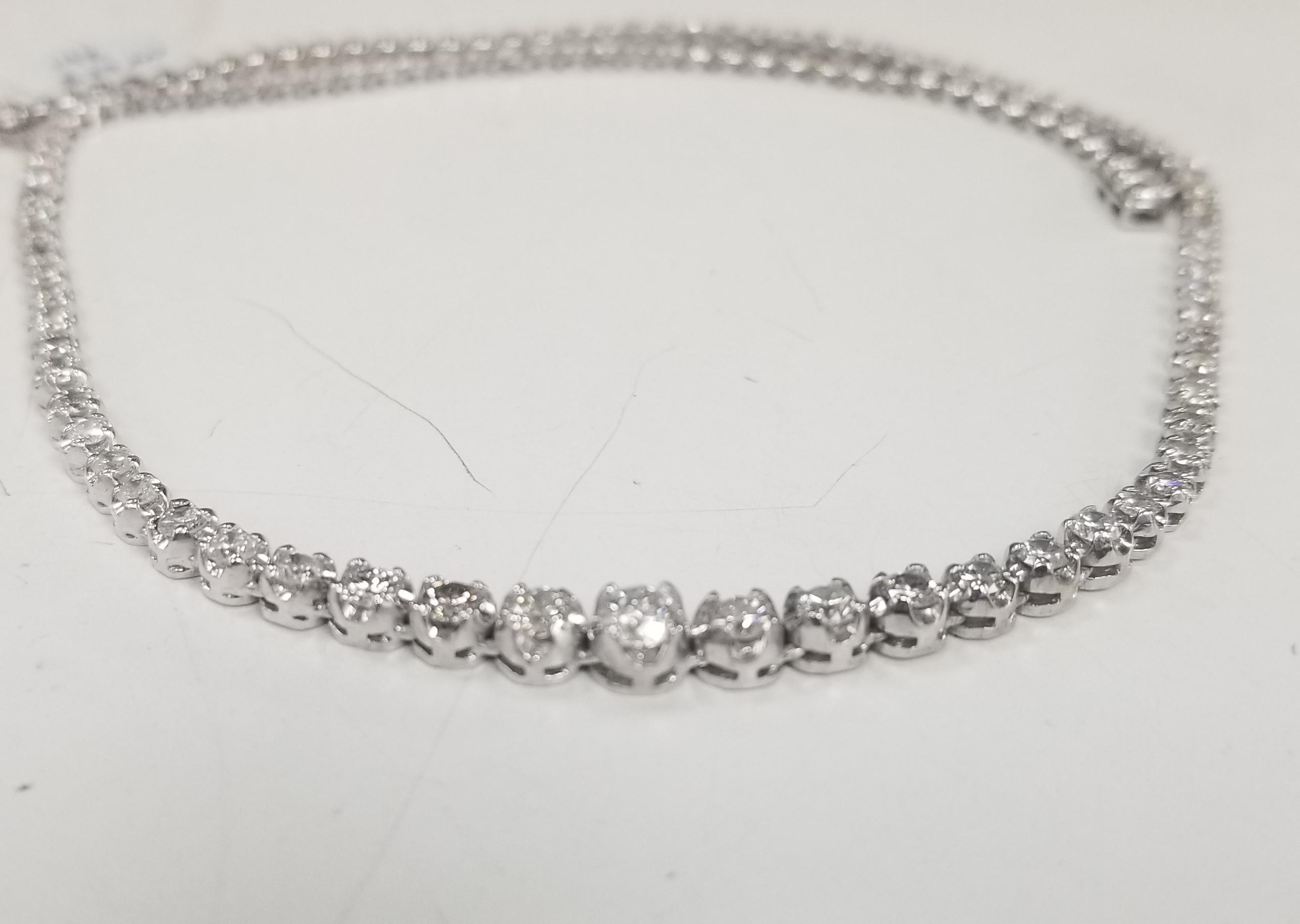 Bring the elegance of your style with this stunning diamond riviera tennis necklace. This piece has 87 pieces of diamonds in 5.56 carat total weight, G color and VS2-SI12 in clarity, crafted in 14k white gold with larger diamonds in front and solid