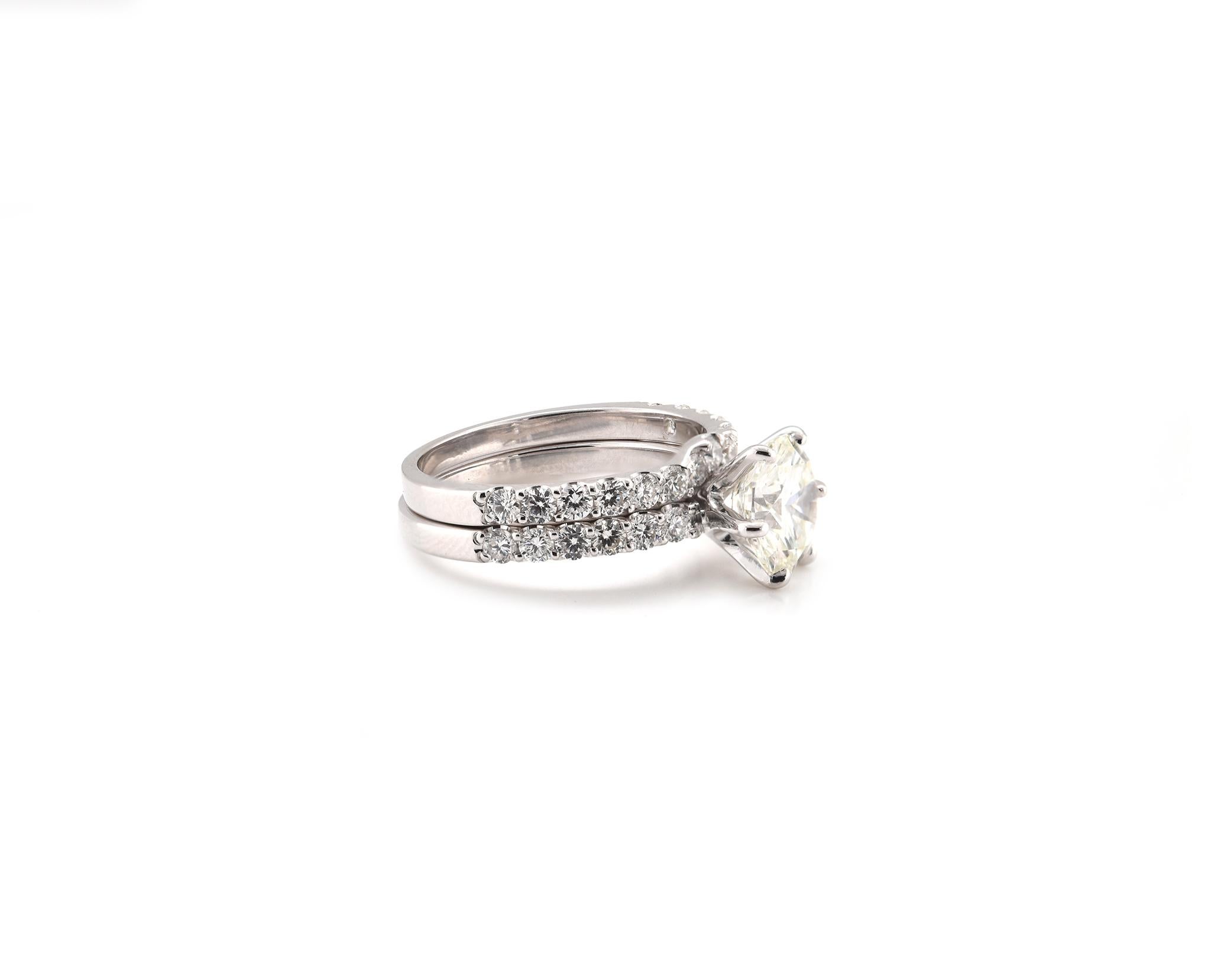 Designer: custom
Material: 14K white gold
Center Diamond: 1 round brilliant cut = 2.10ct
Color: I
Clarity: SI1 
Diamond: 27 round brilliant cut = 1.03cttw
Color: G
Clarity: VS2
Ring Size: 7 (please allow up to 2 additional business days for sizing