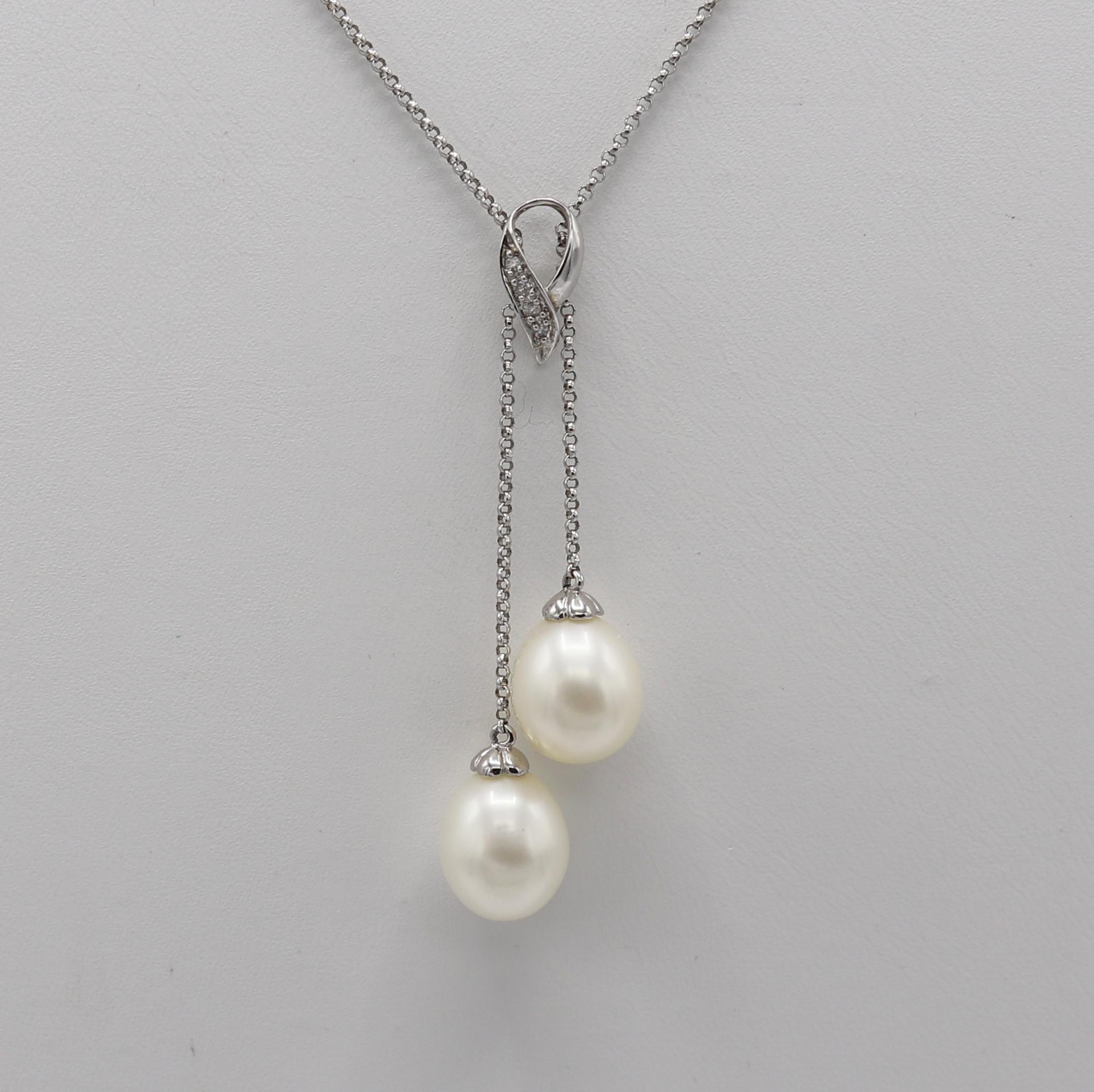 14 Karat White Gold Double Pearl & Natural Diamond Dangle Drop Necklace 
Metal: 14k white gold
Weight: 5.11 grams
Diamonds: .04 CTW H-I SI round natural diamonds
Drop: 2 inches
Chain: 17 inches
Pearls: 9 x 11mm
