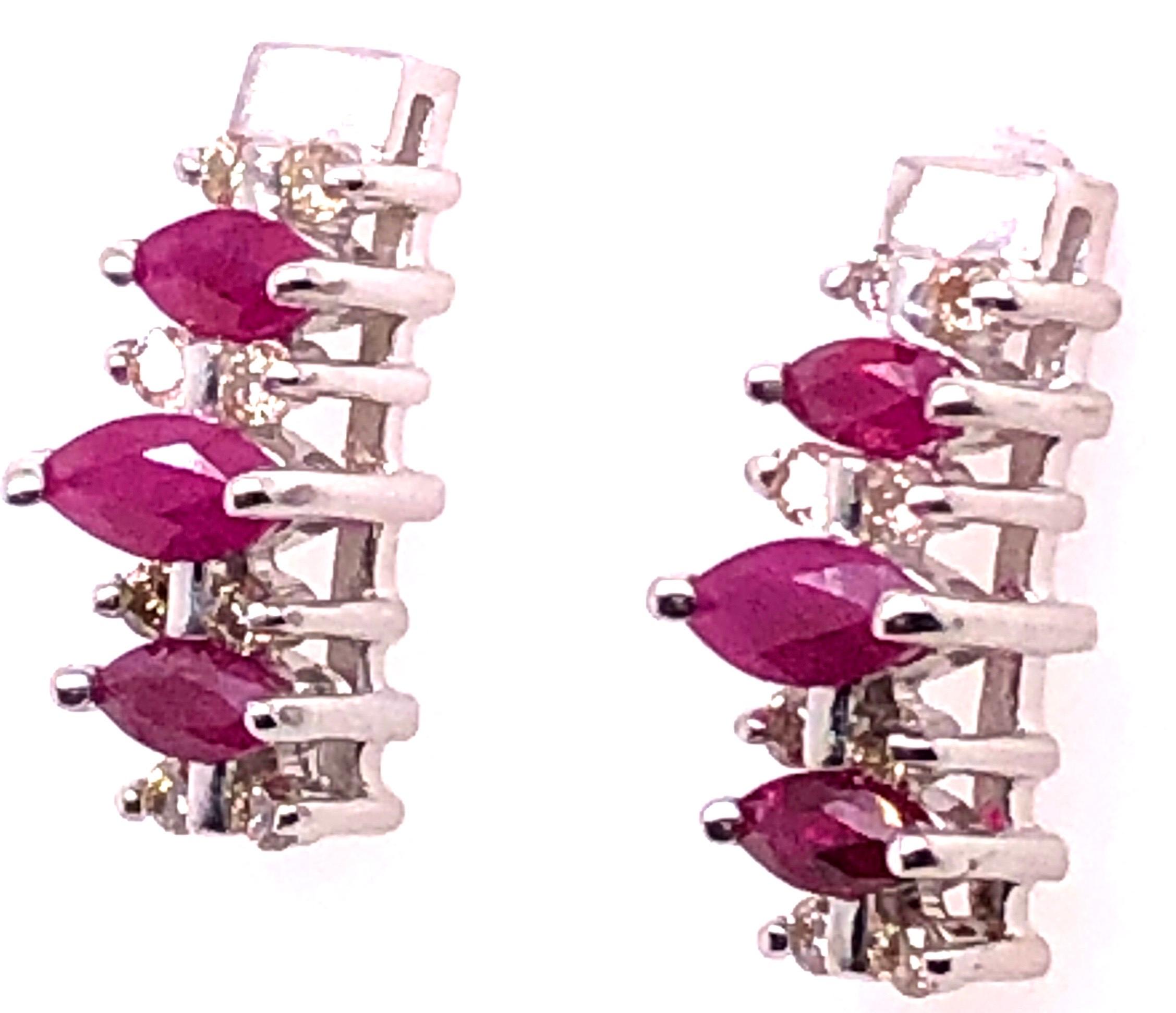 14 Karat White Gold Free Form Button Ruby Earrings with Diamonds.
0.32 total diamond weight.
2.53 grams total weight.