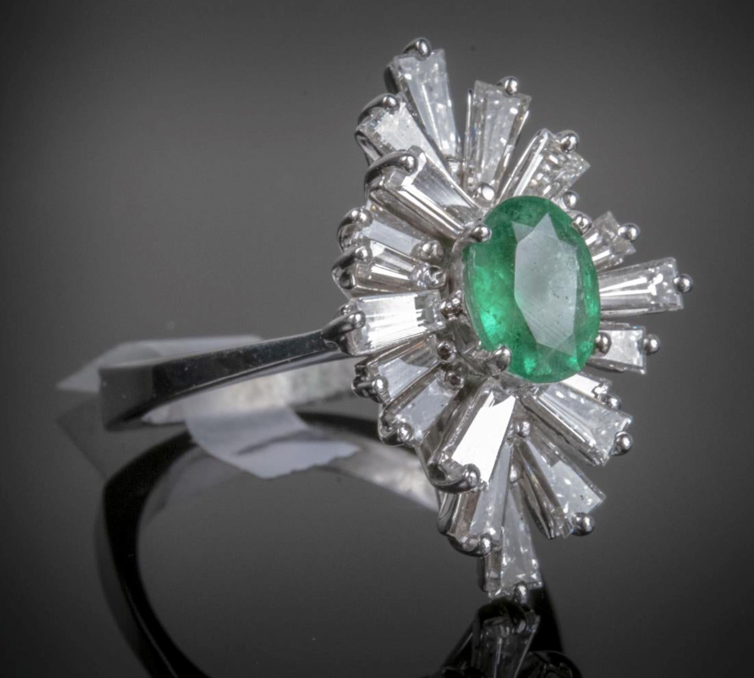 14k white gold ring set with an oval faceted emerald (.65 carat) within a border of twenty baguette diamonds, (tcw 1.35).  Size 5 1/2,  5.44 grams.  