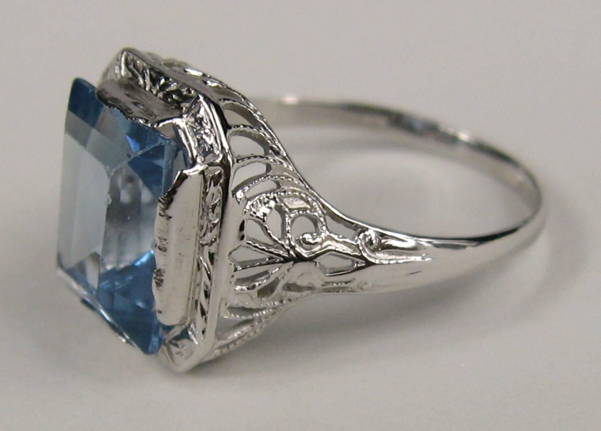 Stunning Open cut work on this 1920's Ring. Emerald-Cut blue topaz set in 14K White Gold. Ring measures 1/2 inch top to bottom or 13mm. The ring is a size 6-3/4 and can be sized by us or your jeweler. This is out of a massive collection of New Old