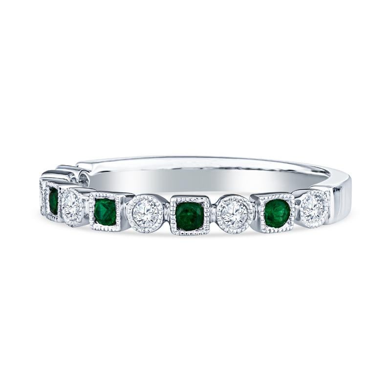 This unique band features alternating shapes with round emeralds and diamonds set in 14 karat white gold with milgrain detail. This ring is a size 6.5 but can be resized upon request.