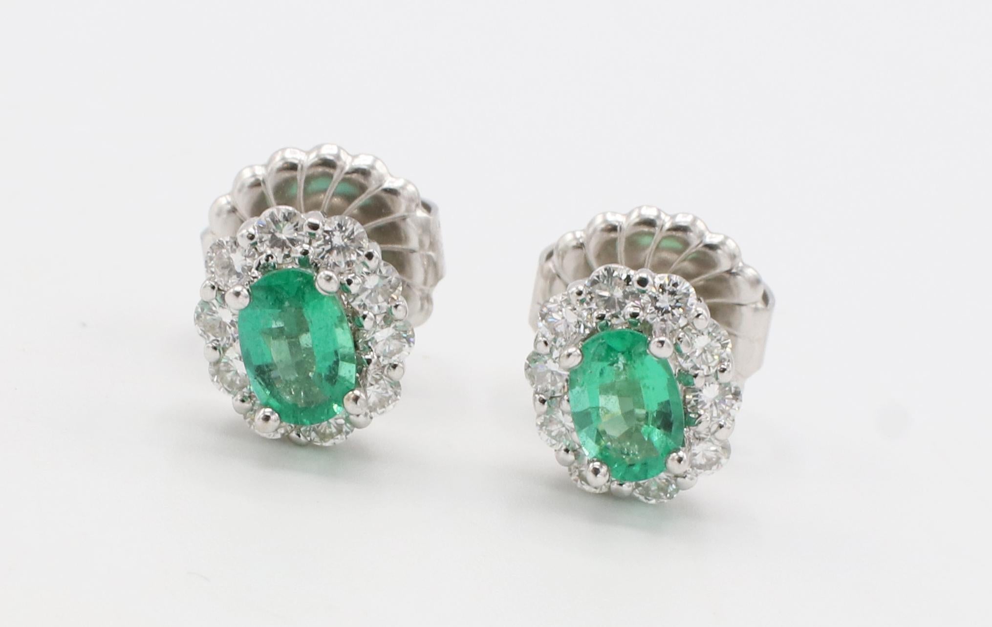 Oval Cut 14 Karat White Gold Emerald and Natural Diamond Halo Stud Earrings  For Sale
