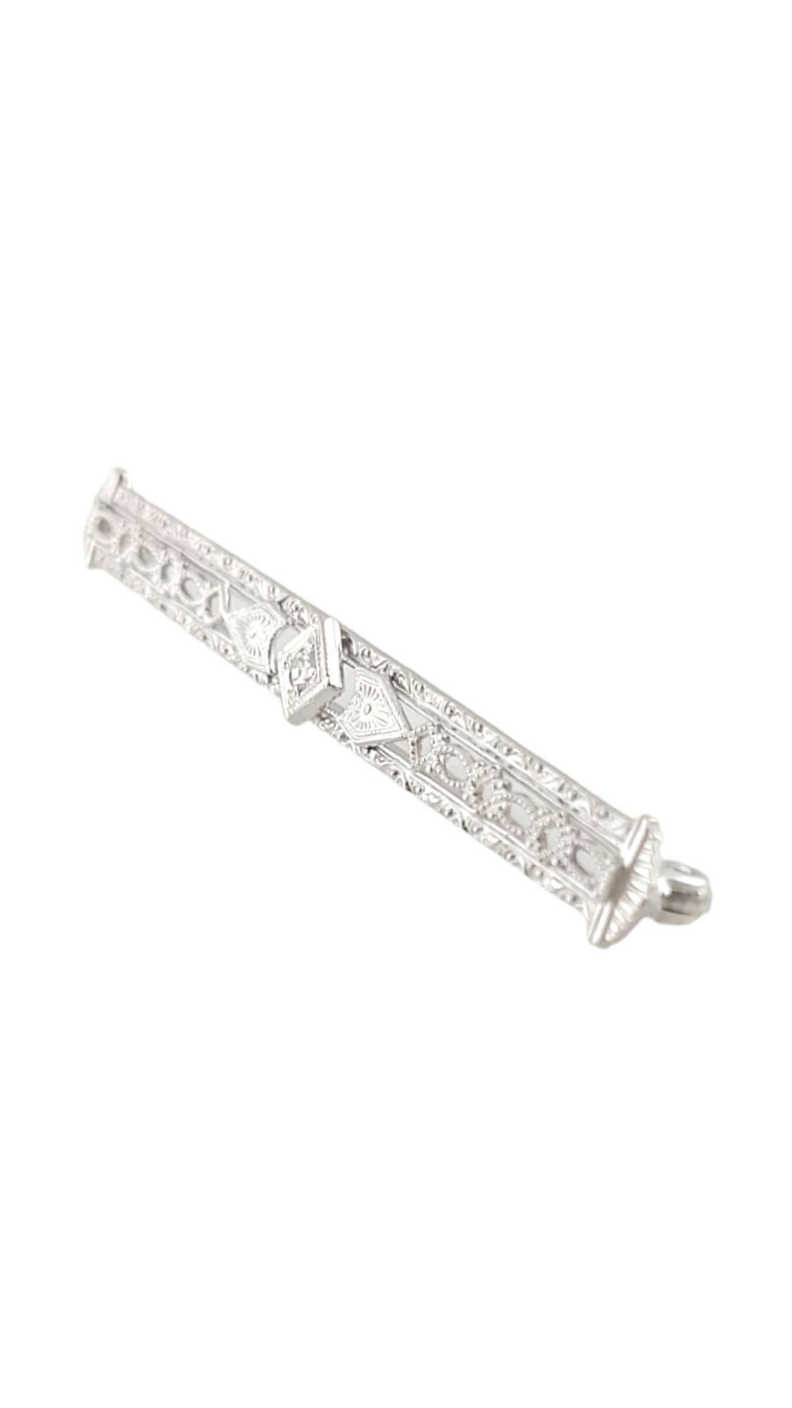 This elegant bar pin features one round single cut diamond set in beautifully detailed 14K white gold filigree. Width: 5 mm

Approximate total diamond weight: .03 ct.

Diamond color: H

Diamond clarity: I1

Size: 2 inches

Weight:  2.8 gr./  1.8
