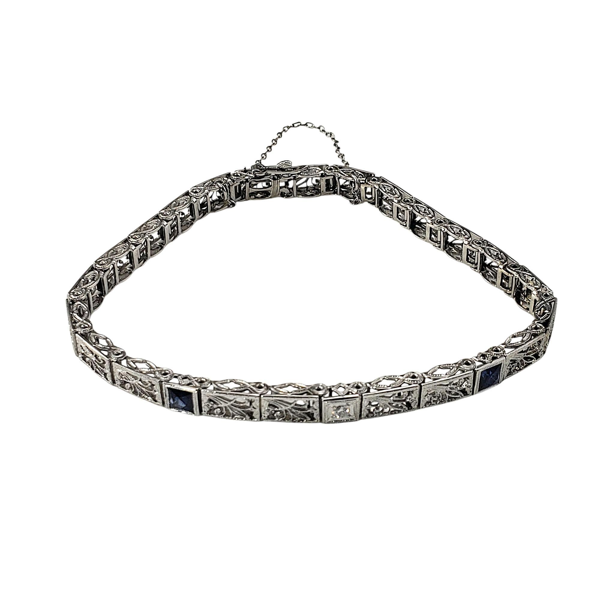 14 Karat White Gold Filigree and Diamond Bracelet-

This stunning bracelet is crafted in 14K white gold filigree and features two round brilliant cut diamonds and two faceted blue stones, adding sparkle and a pop of color to the piece. 

Width: 5