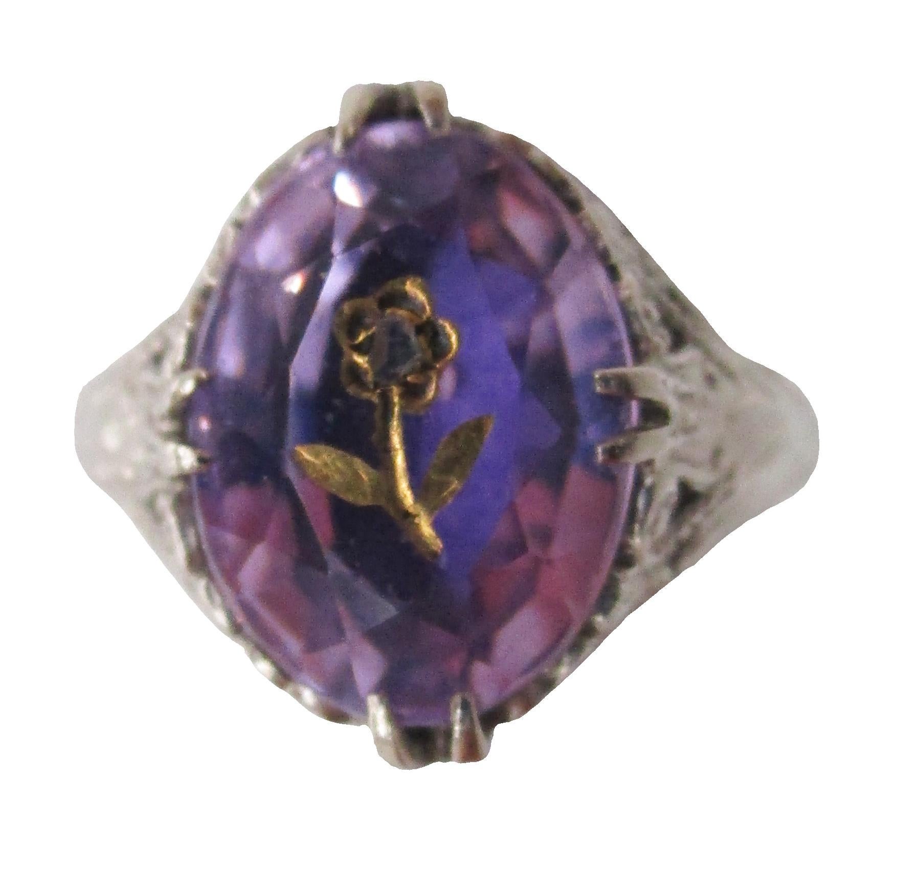 This gorgeous antique ring dates back to the 1920s and incorporates a dramatic pierced filigree shoulder and under-gallery into a stunning ring that boasts a killer Rose de France amethyst center stone accented by a gold diamond accented inlaid