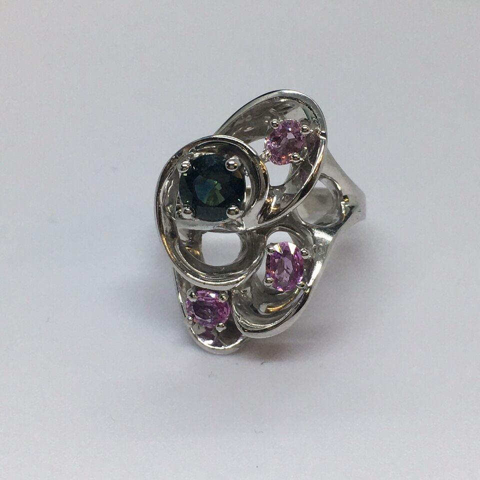 14 Karat White Gold Free form Pink Sapphire Statement Ring 

Weighting 10.8 Gram 
Finger Size 7
Measurements 1 inch top span on vertical direction  
Condition good condition, no evidence of repairs


The Blue-Green round faceted Sapphire changes