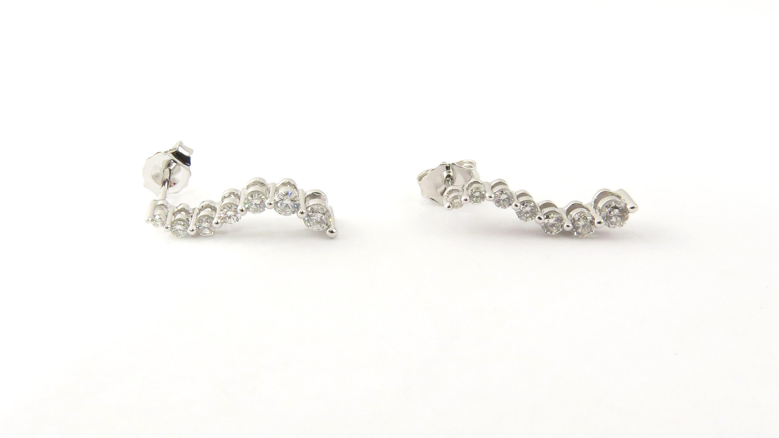 Vintage 14 Karat White Gold Graduated Diamond Earrings

These sparkling earrings each feature seven round brilliant cut diamonds set in a classic curved design. Push back closures.

Approximate total diamond weight: .39 ct.

Diamond color: