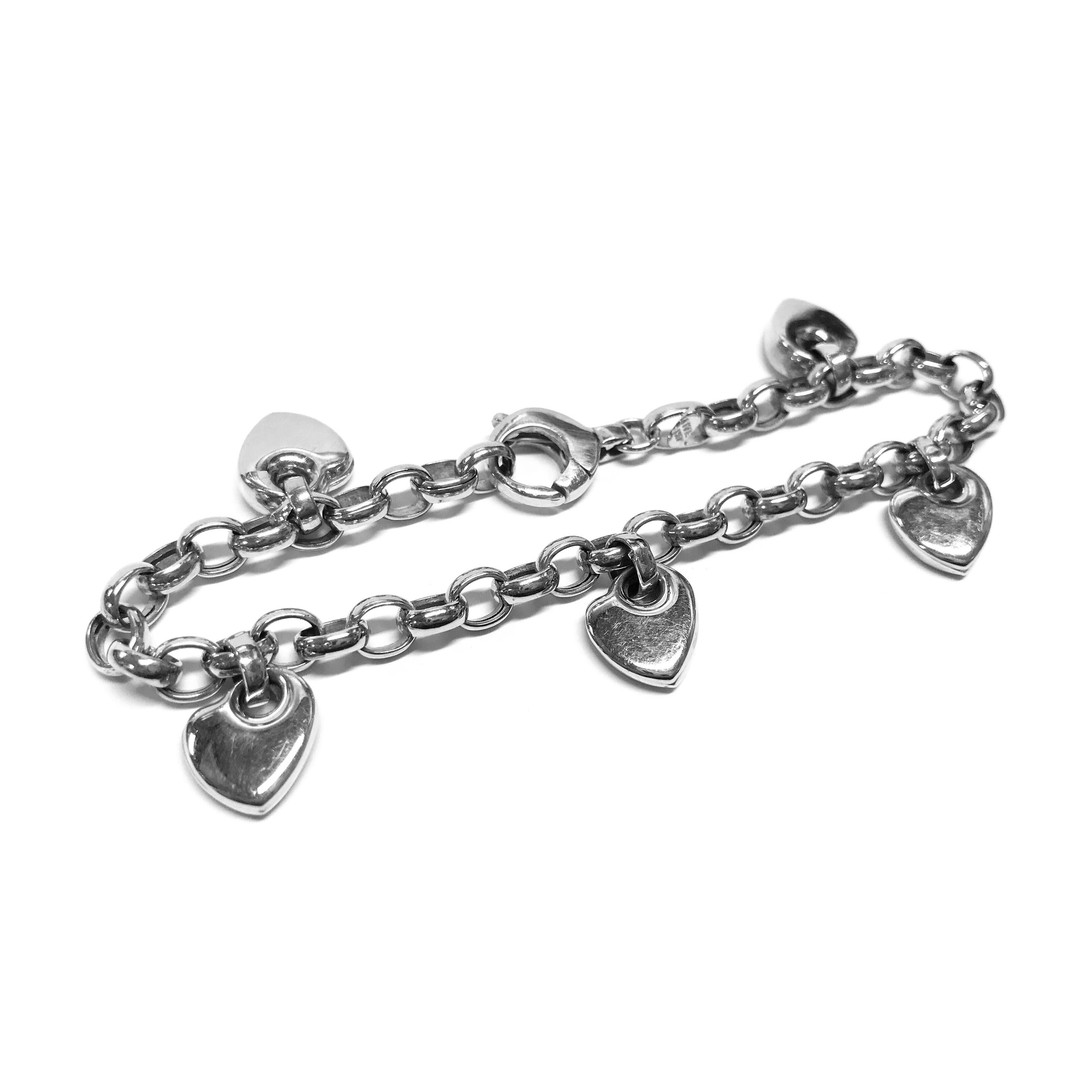 14 Karat White Gold Italian Heart Charm Bracelet. This bracelet features five heart-shaped charms that hang on the links of the rolo chain. The bracelet is 7