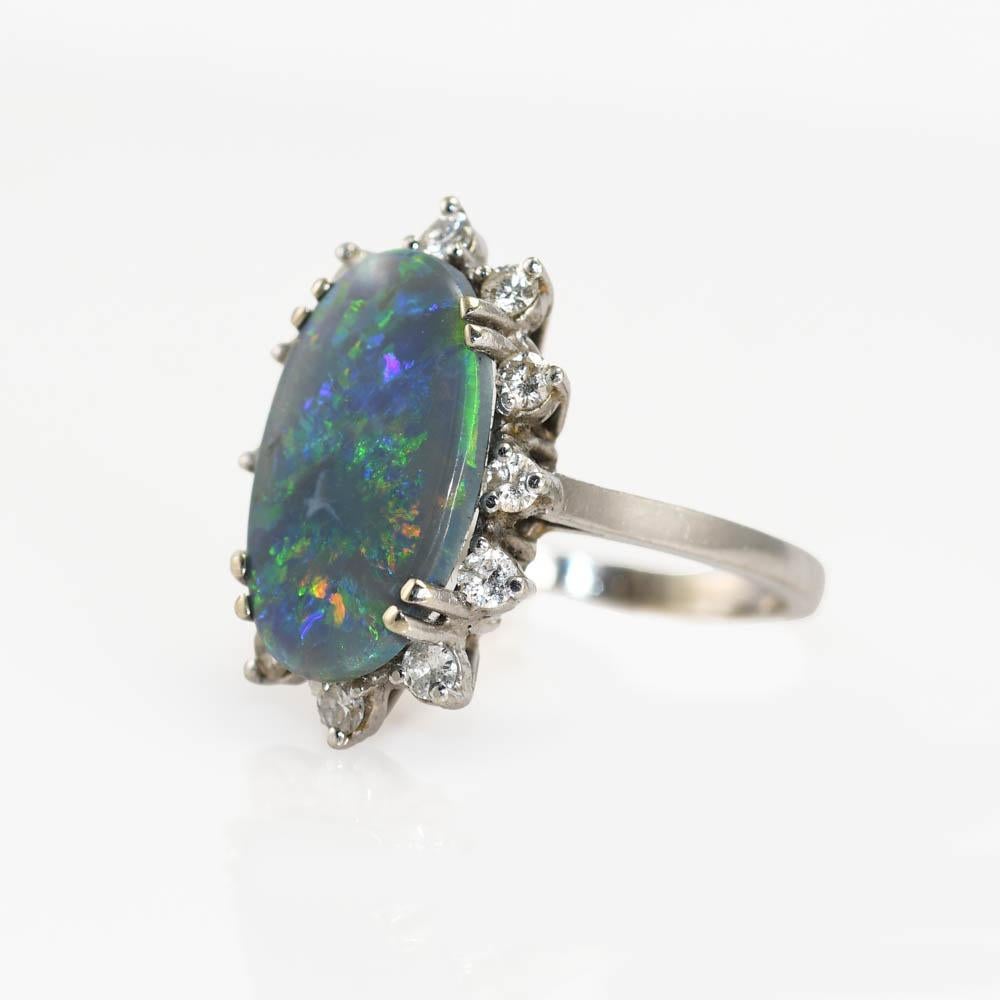 This Is A 14k White Gold Ladies Australian Black Opal And Diamond Ring.
The Main Stone Is A Solid 17 X 10 Millimeter Oval Opal.
The Opal Is Accented By 12 Round Cut Diamonds With A Total Weight Of 0.24 Carats. With SI Clarity And H Color.
The Ring