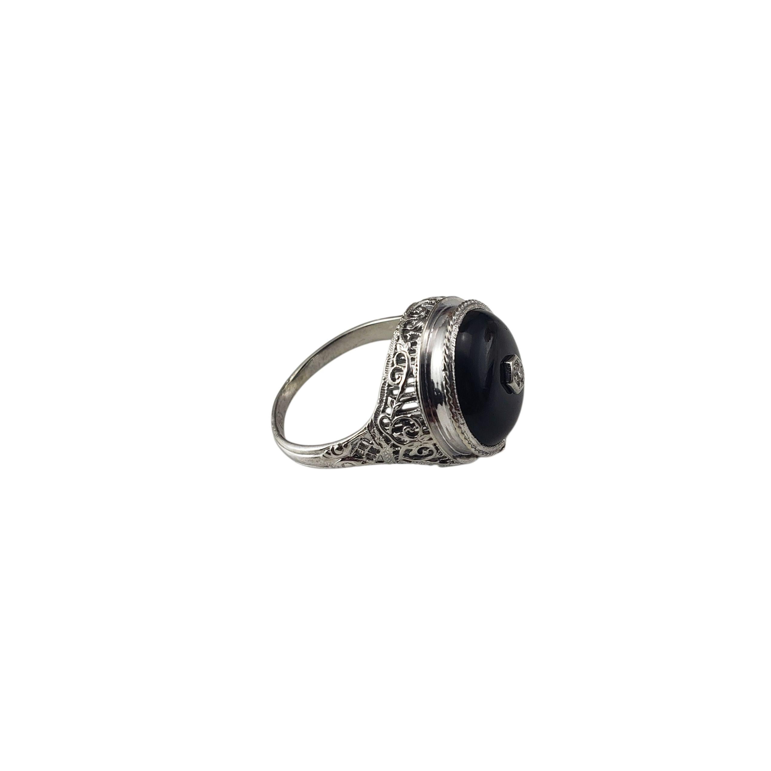 Bague en or blanc 14 carats avec onyx et diamants Taille 6.5

Cette magnifique bague présente un onyx noir serti dans un filigrane d'or blanc 14 carats magnifiquement détaillé. Un diamant rond à taille unique est serti au centre de l'onyx, ajoutant