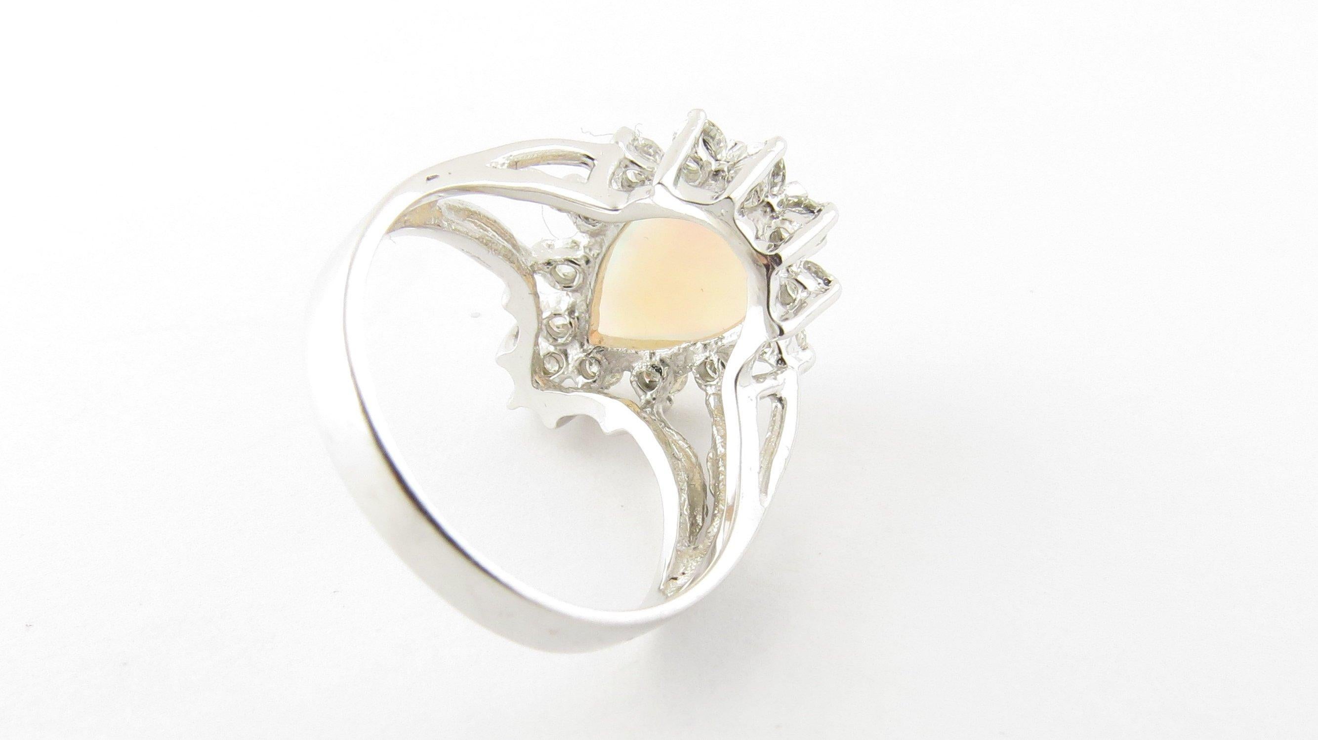 Vintage 14 Karat White Gold Opal and Diamond Ring Size 5.25- This stunning ring features one pear-shaped opal (14 mm x 10 mm) surrounded by 13 round brilliant cut diamonds and set in classic 14K white gold. Top of ring measures 17 mm x 13 mm. Shank