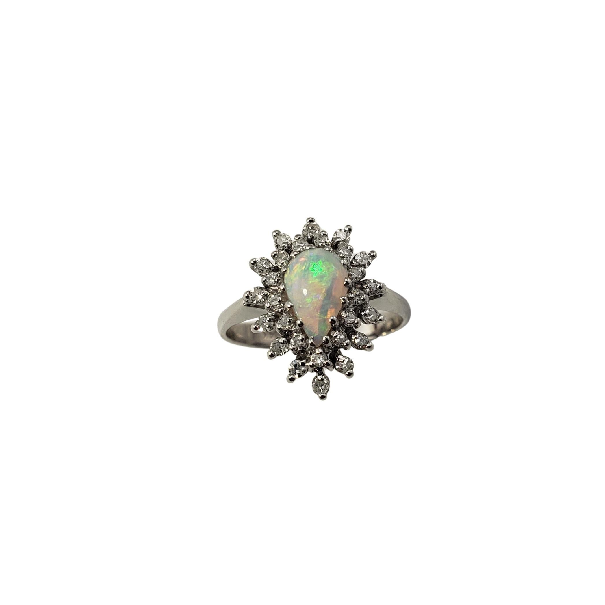 14 Karat White Gold Opal and Diamond Ring Size 5.75-

This lovely ring features one pear shaped opal (9 mm x 5 mm) surrounded by 27 round single cut diamonds set in classic 14K white gold.  Top of ring measures 16 mm x 12 mm.  Shank:  3