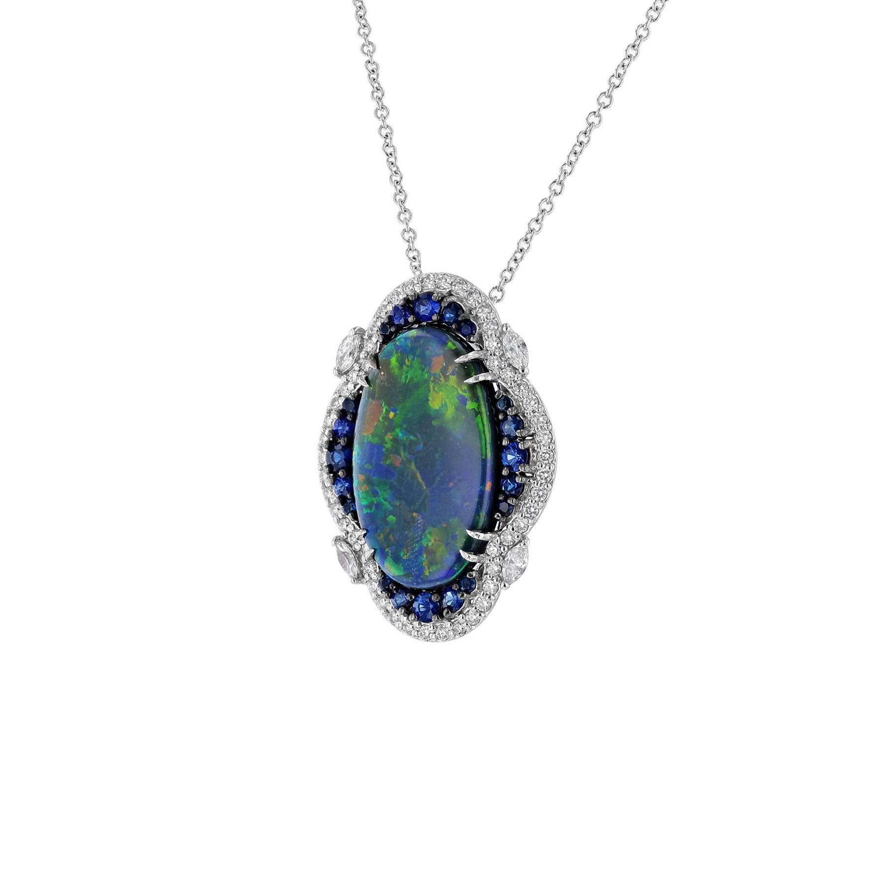 This necklace is made in 14K white gold. It features an oval shaped, iridescent opal weighing 8.22 carats. Surrounded by 20 round cut blue sapphires weighing 0.63 carats. Within a frame of 54 round cut diamonds and accented with 4 marquise cut